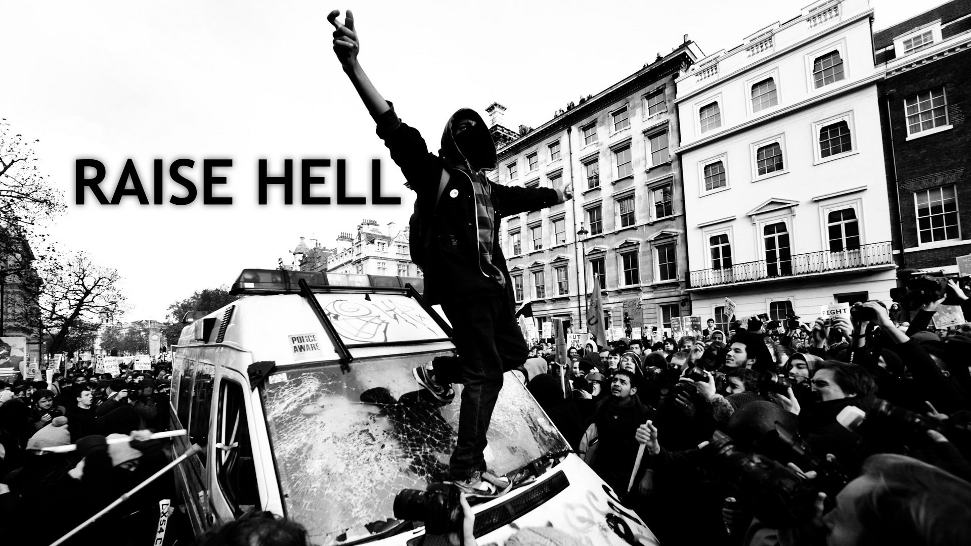 Protester on top of a police van with crowd HD Wallpaper