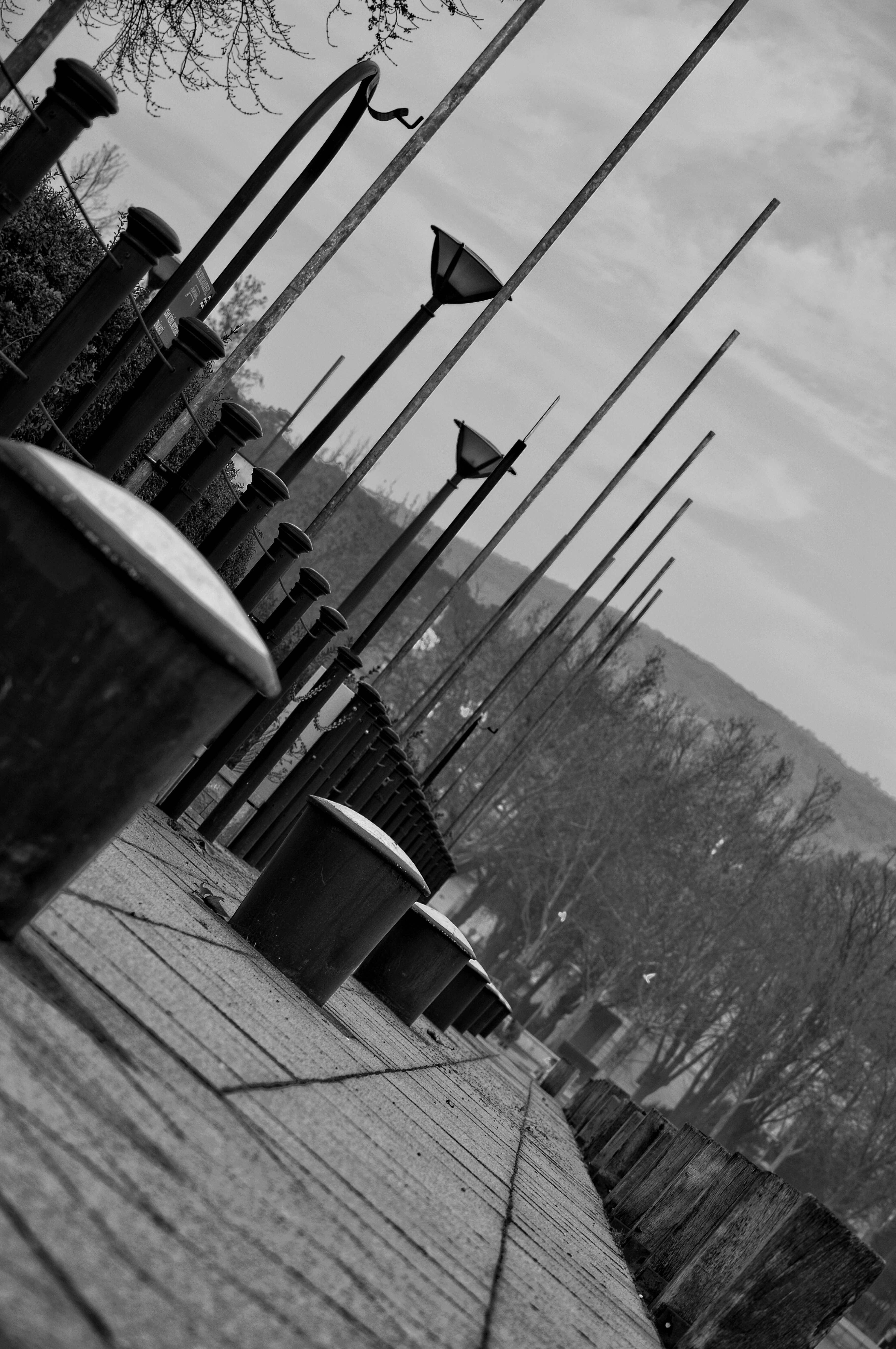 Monochrome image of a dock with bollards and lampposts HD Wallpaper