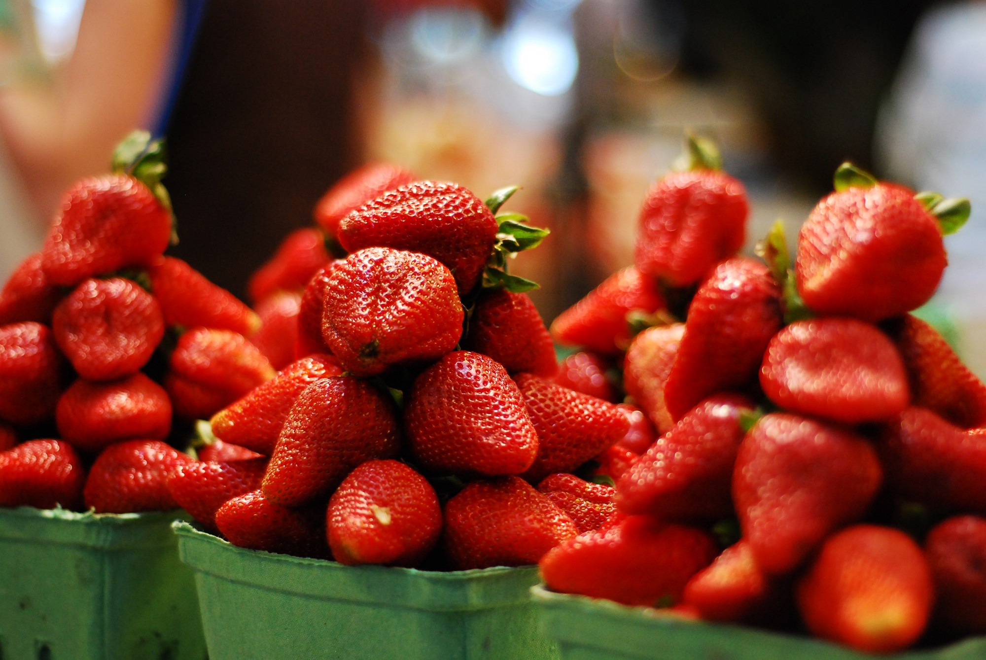 Piles of fresh strawberries in green containers HD Wallpaper
