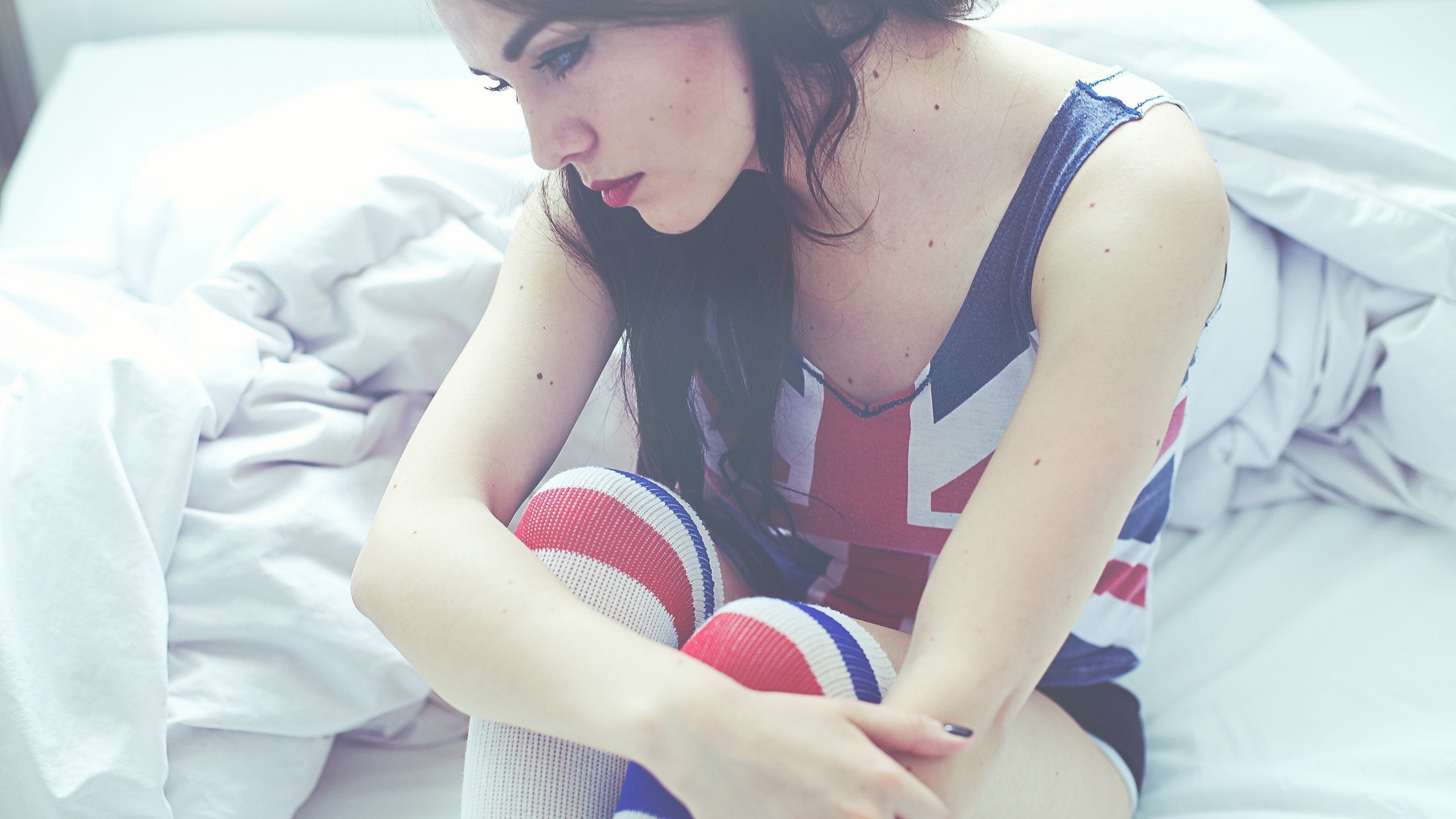 Woman in Union Jack top and knee-high socks on bed HD Wallpaper