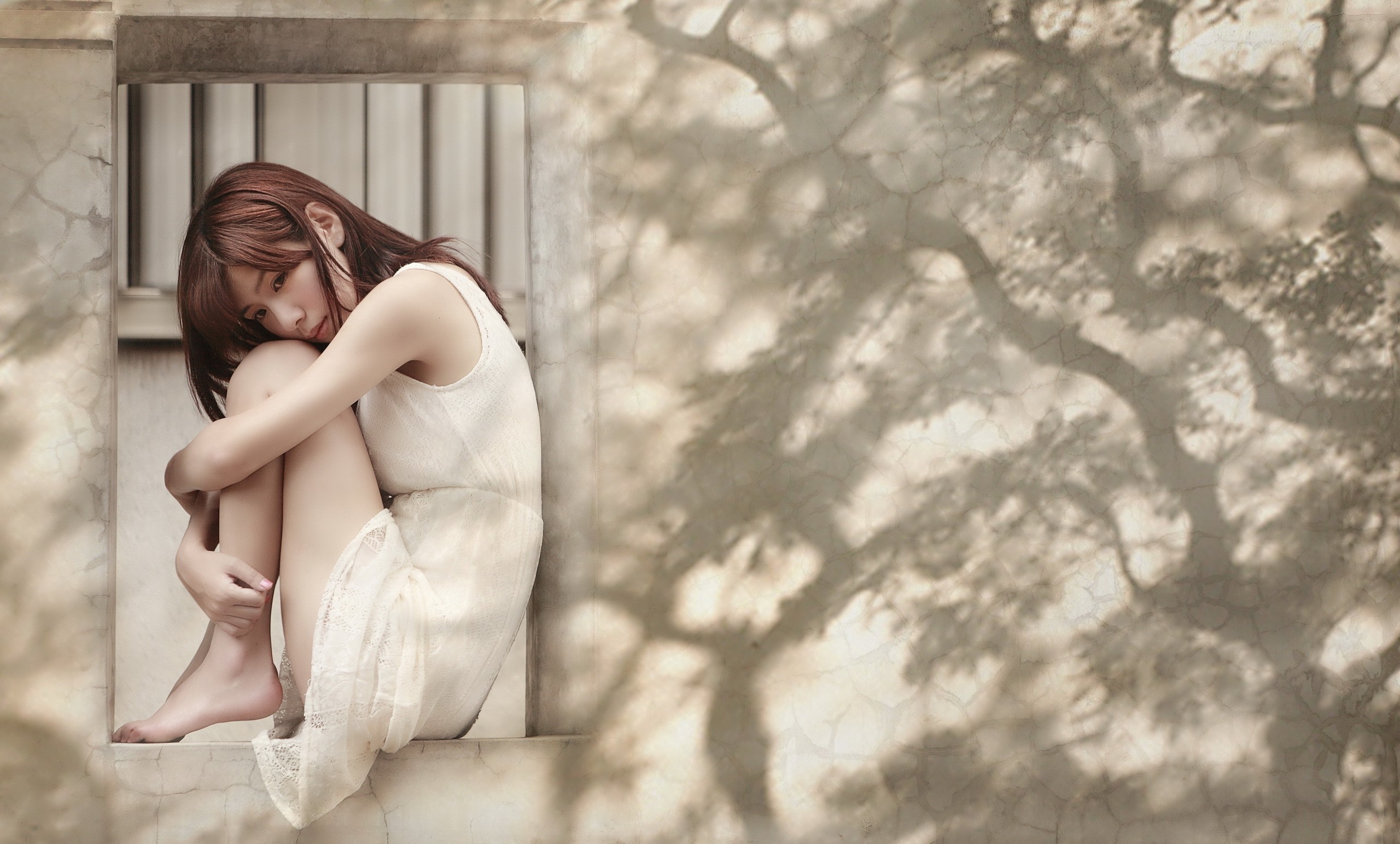 Contemplative Woman in White Dress Sitting by Window HD Wallpaper