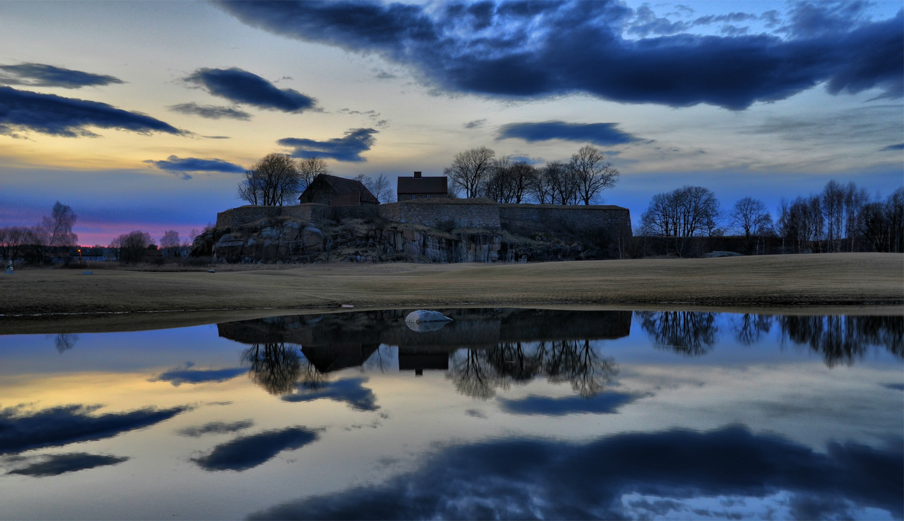 Castle ruins reflected in water at sunset HD Wallpaper