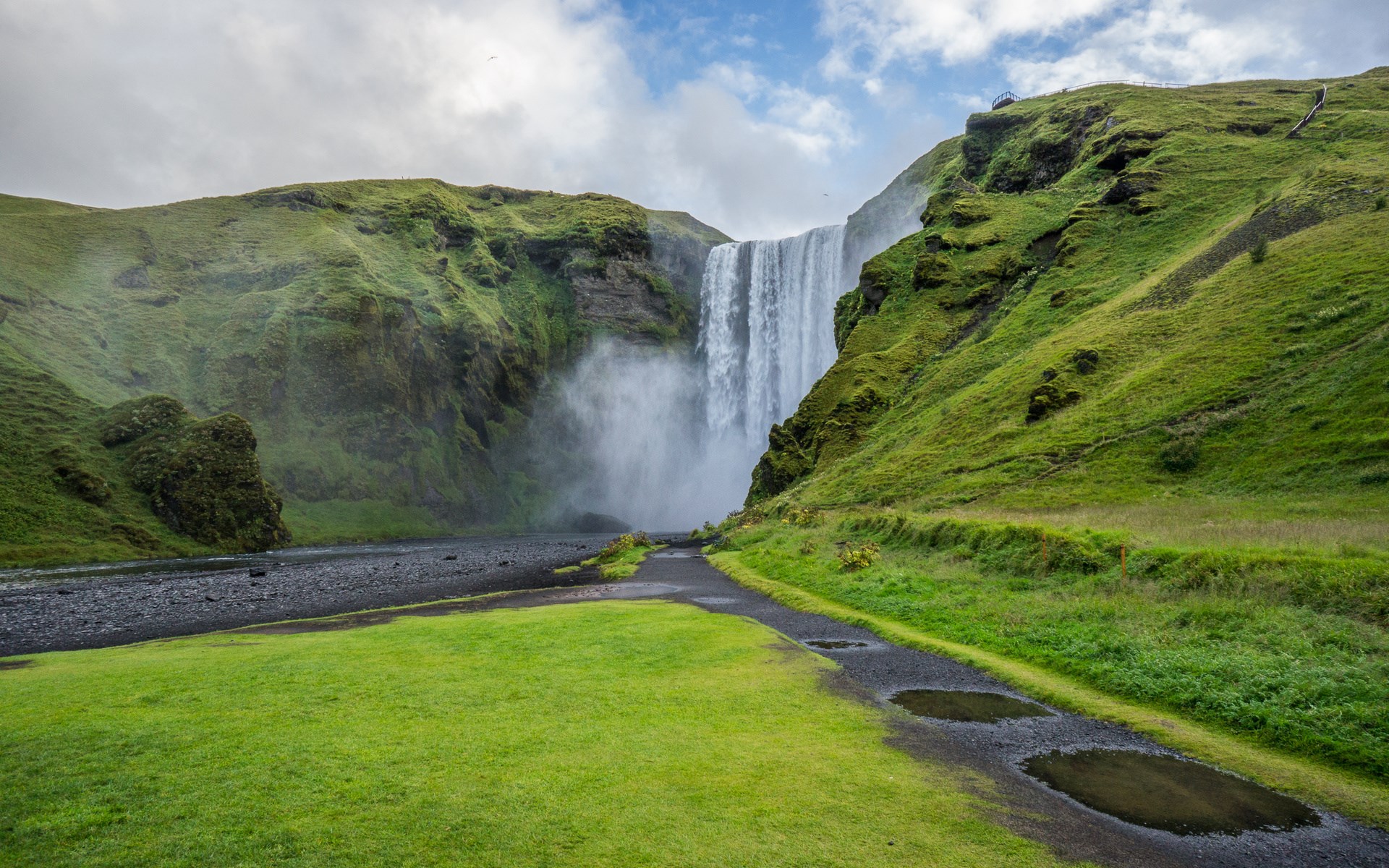 Skogafoss waterfall in Iceland with green hills HD Wallpaper