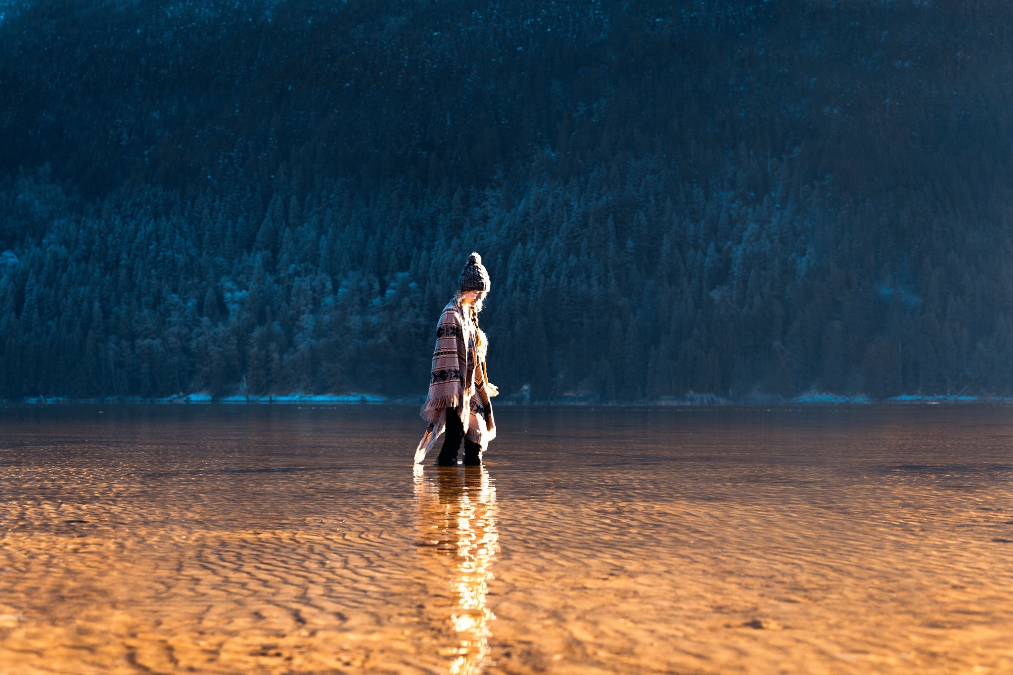 Woman in a poncho walking in a shallow lake HD Wallpaper