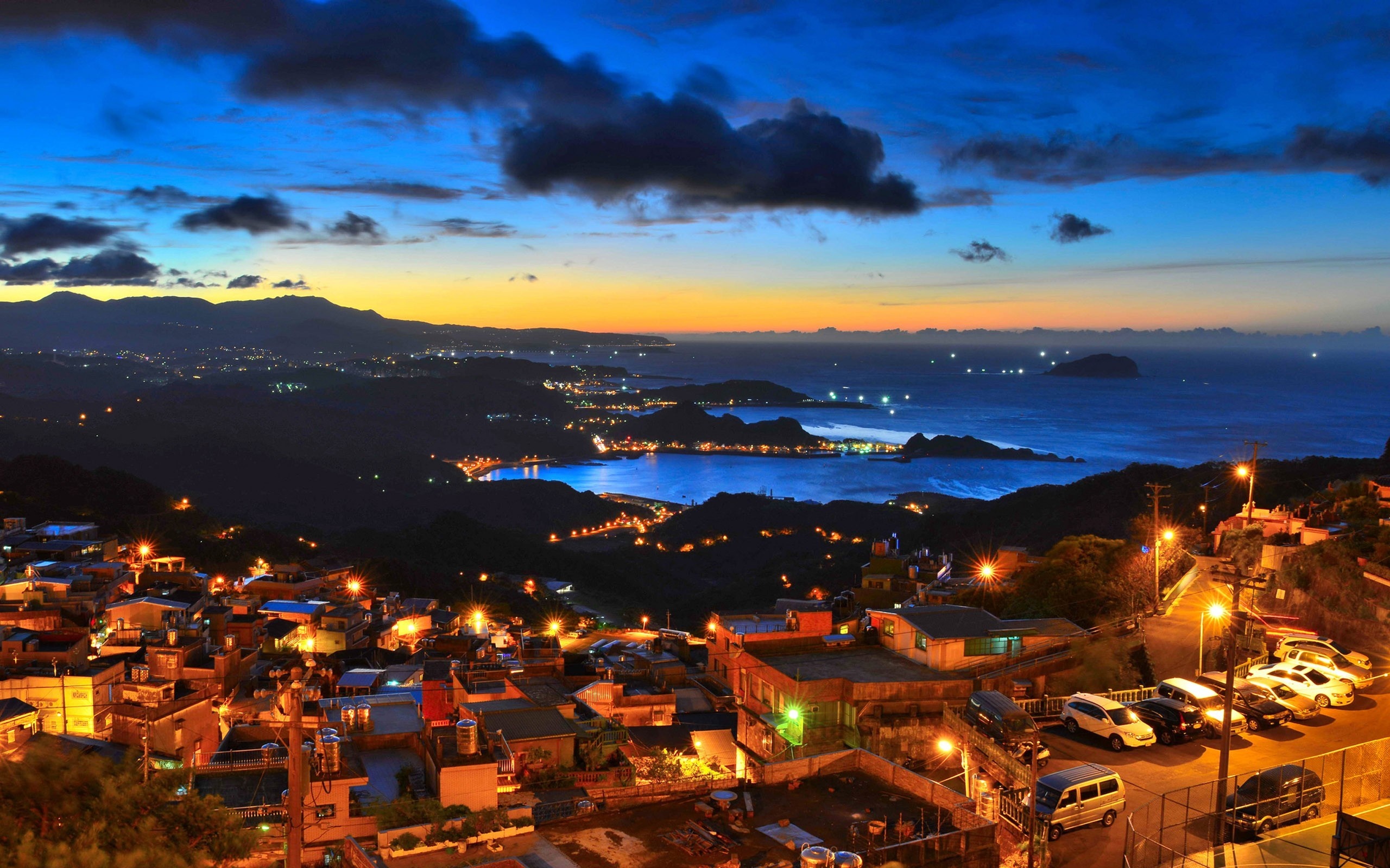 Coastal Cityscape at Dusk with Ocean and Mountains HD Wallpaper