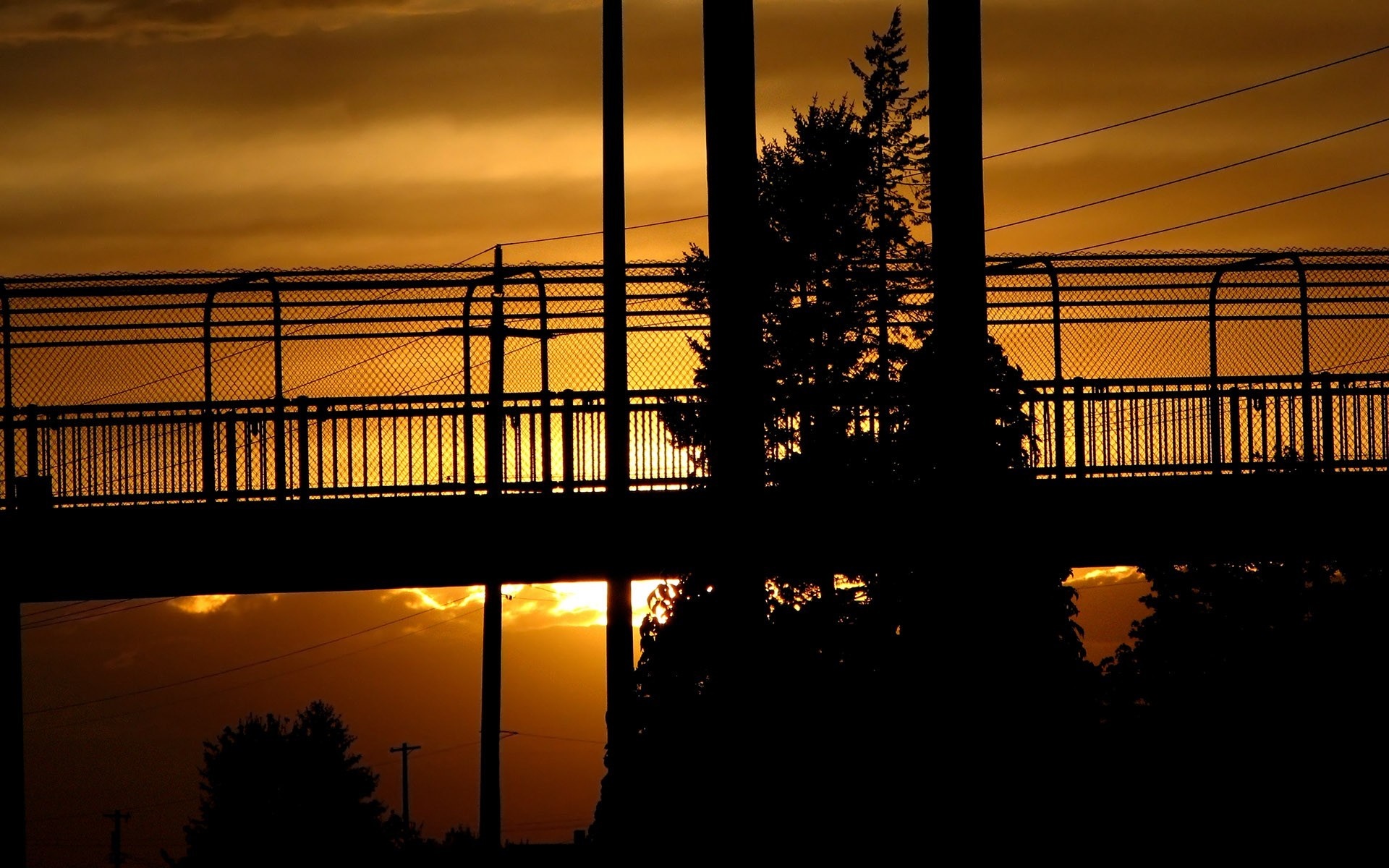 Silhouette of a bridge against a sunset sky HD Wallpaper