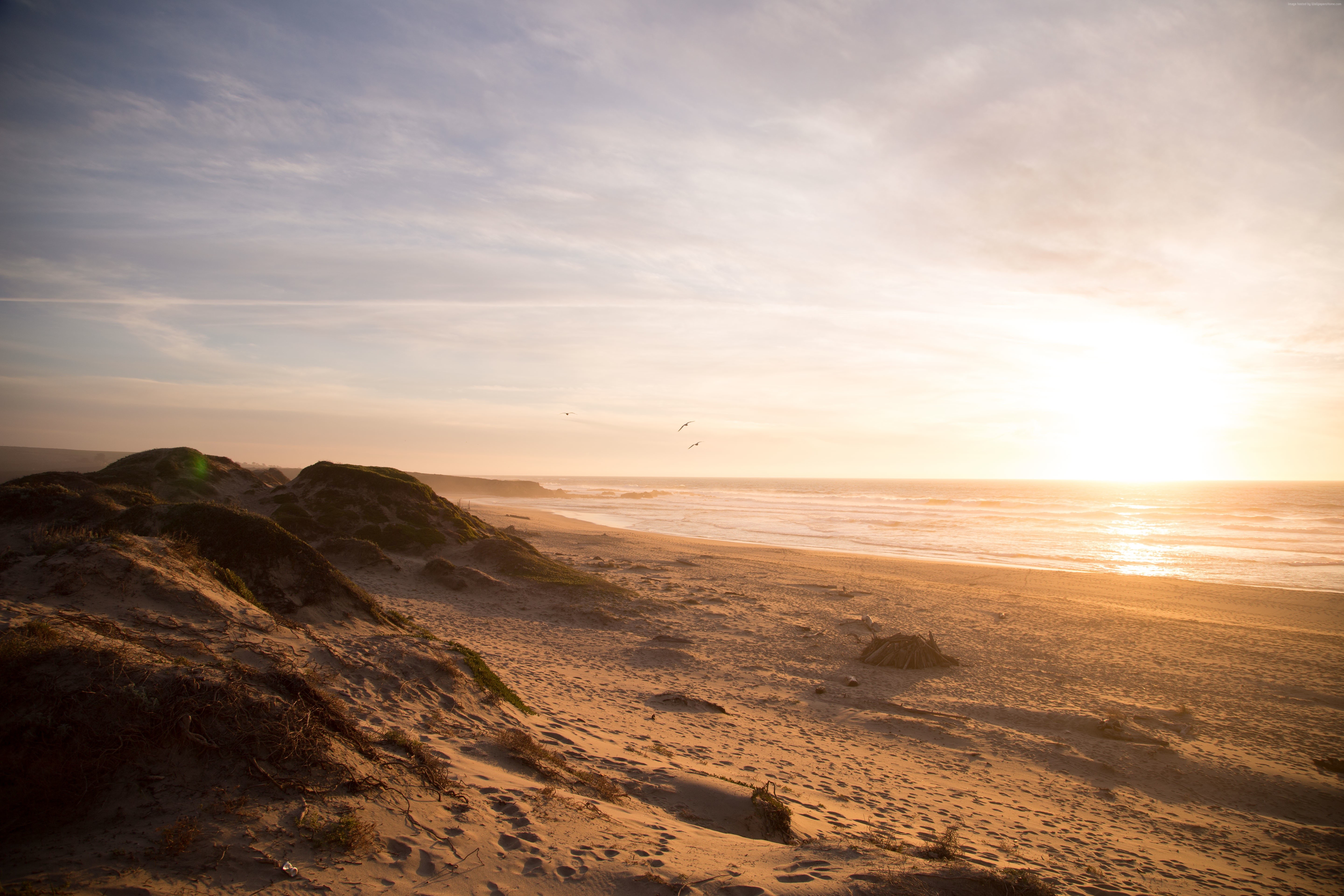 Beach at sunset with ocean waves and sand dunes HD Wallpaper