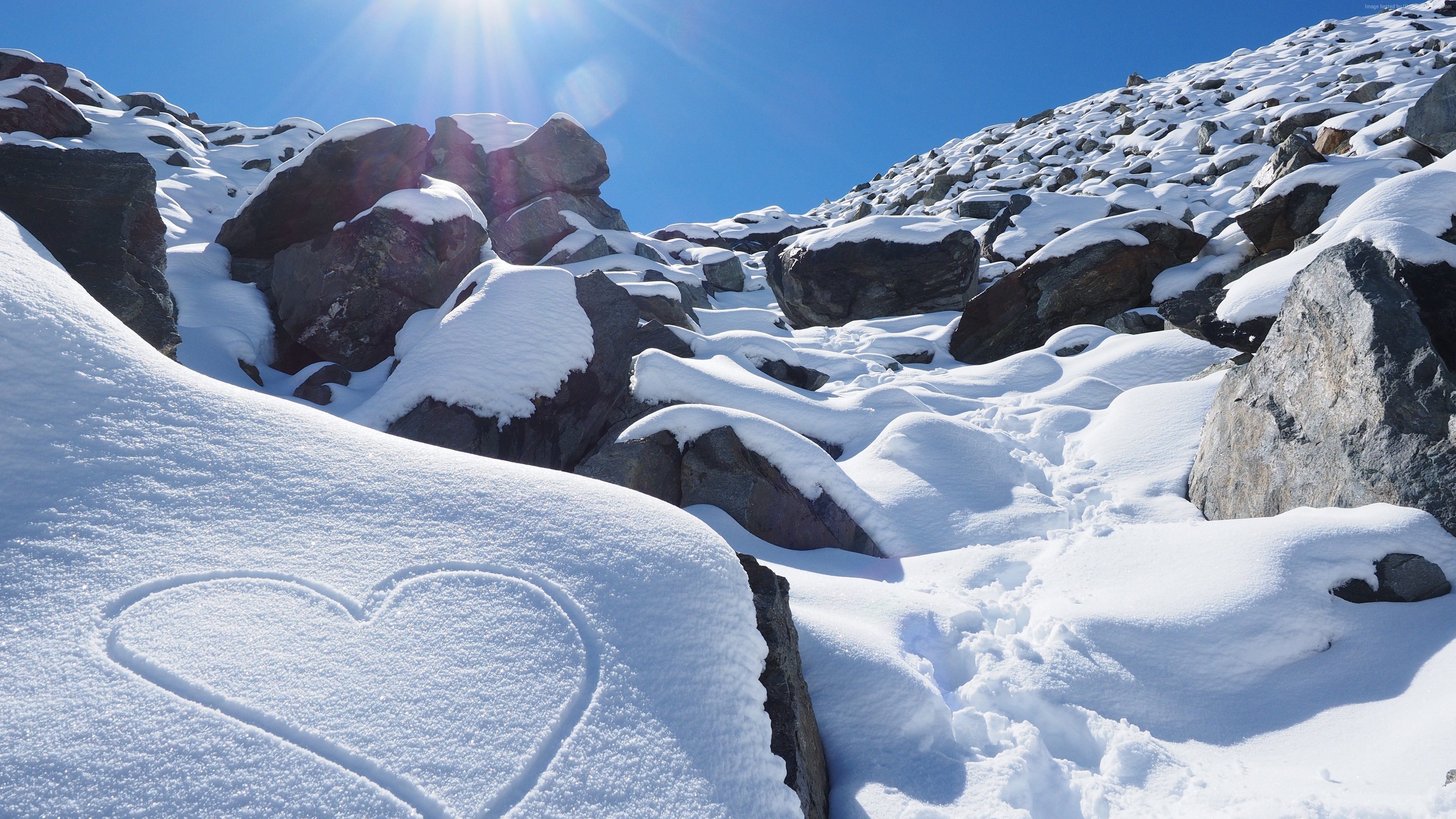 Heart drawn in snow on a rocky mountain slope HD Wallpaper