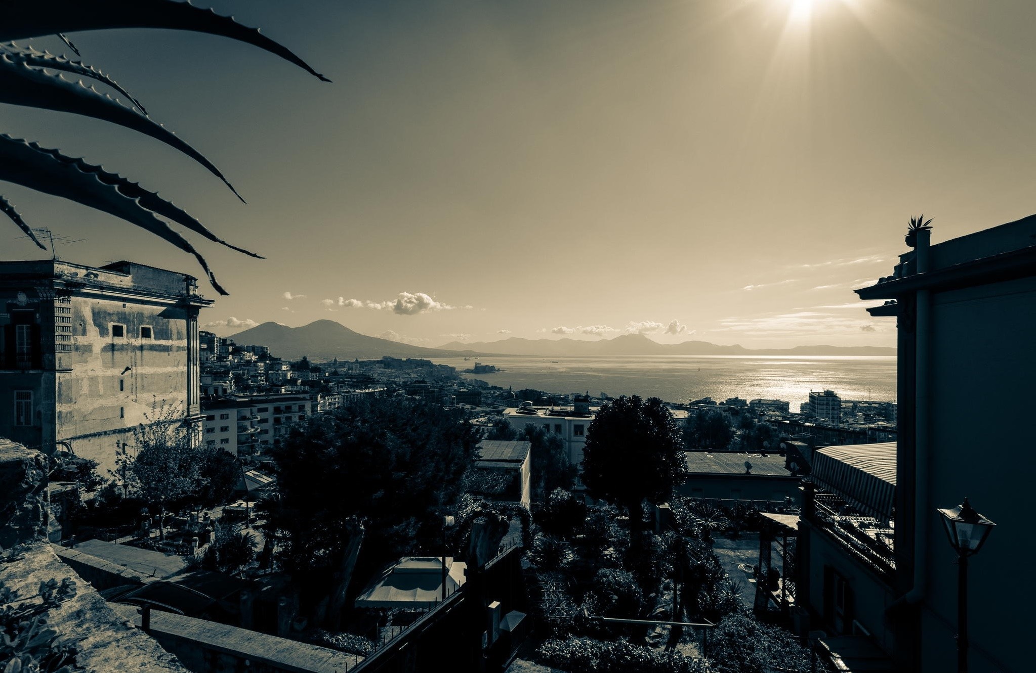 Cityscape overlooking the sea with mountains under sunlight HD Wallpaper