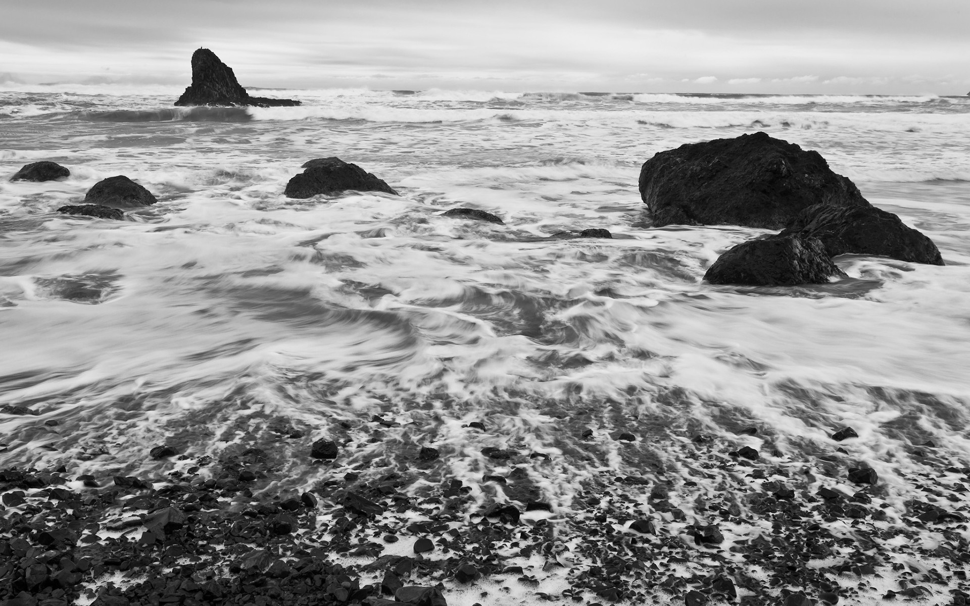 Monochrome image of waves crashing on rocks at the shore HD Wallpaper