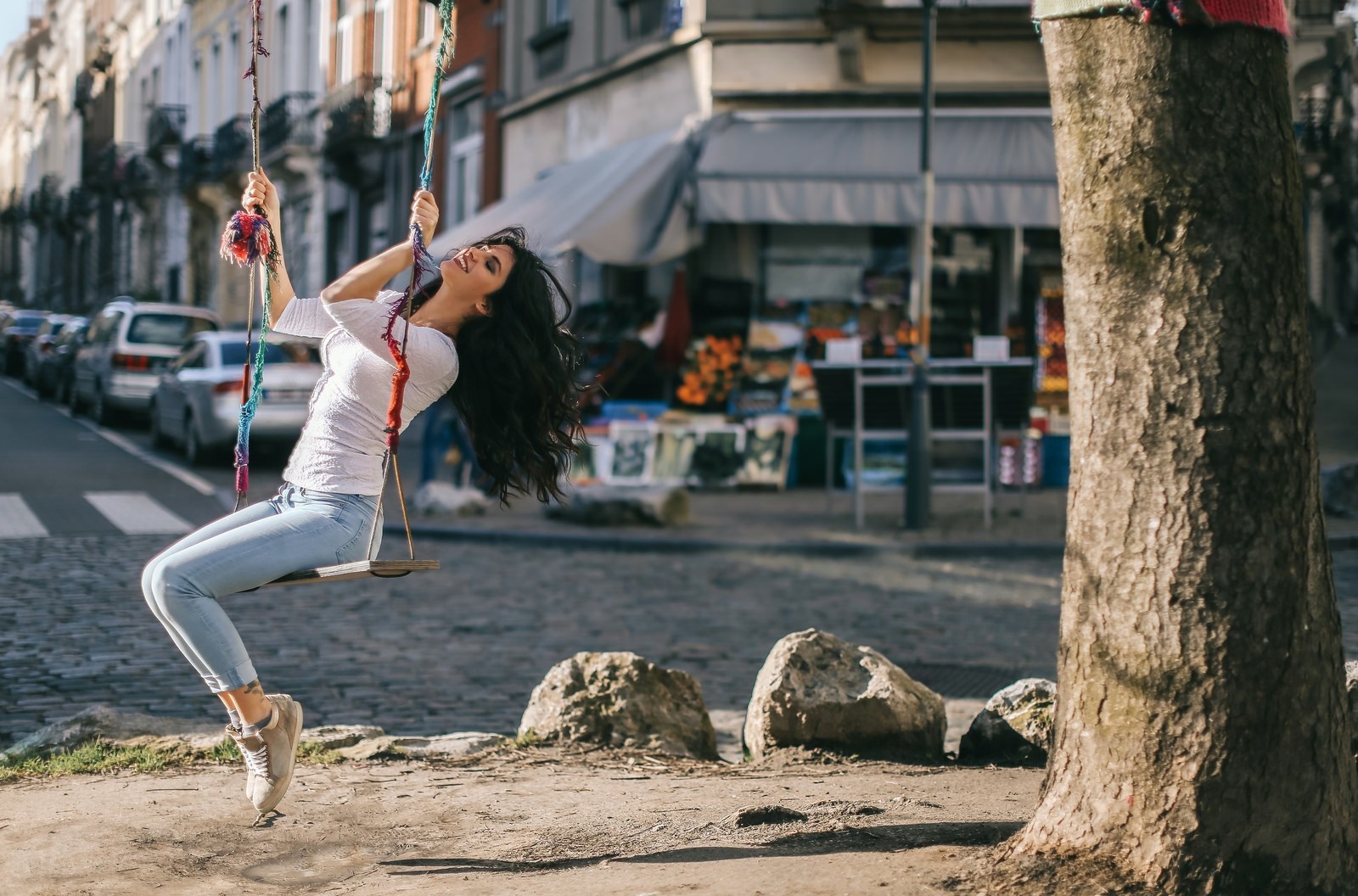 Woman on a swing in a city street HD Wallpaper