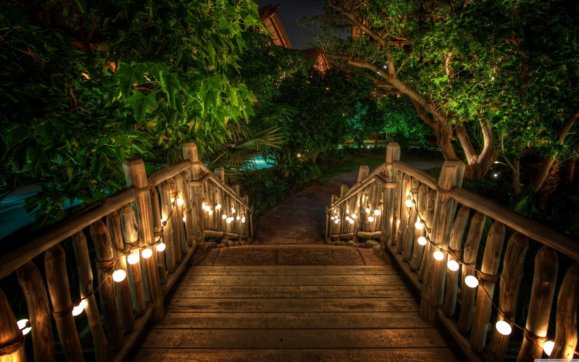 Wooden bridge with string lights at night HD Wallpaper