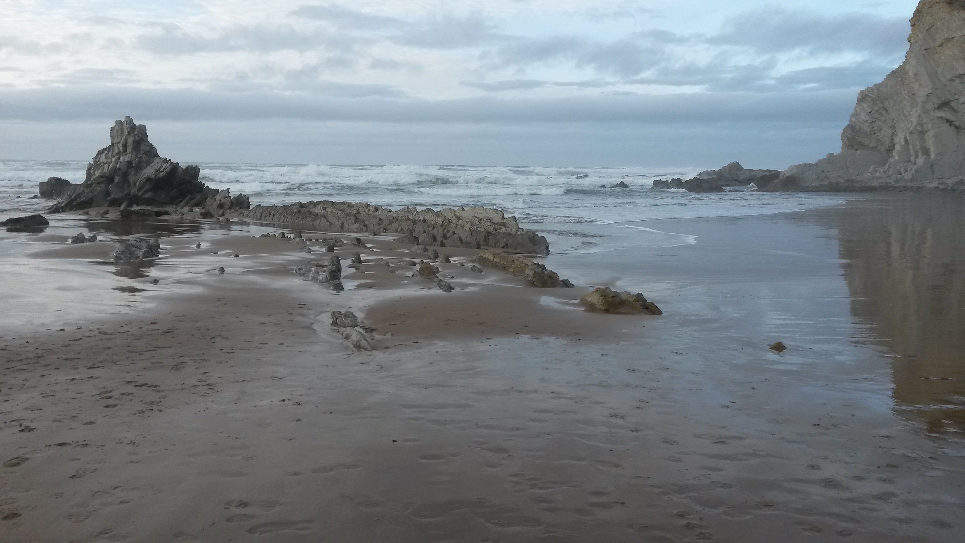 Rocky beach with waves crashing on shore HD Wallpaper