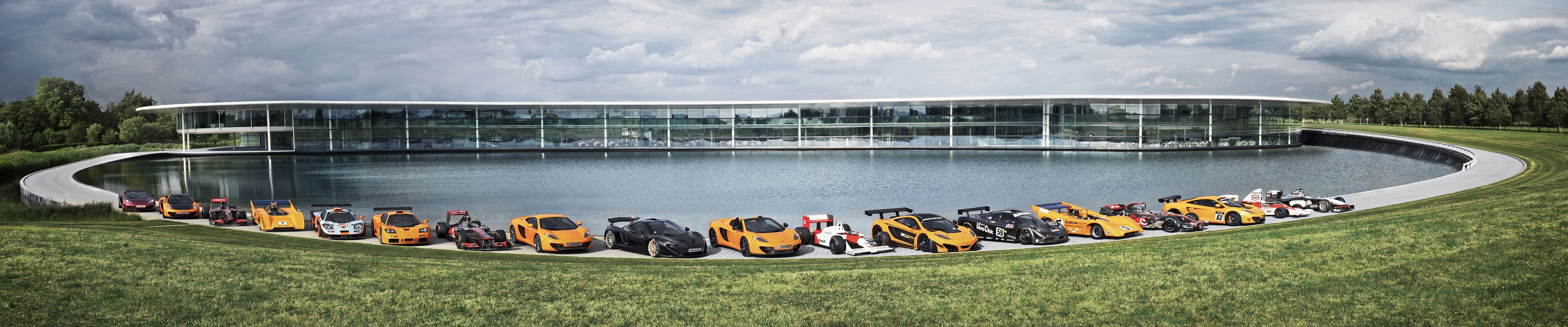 McLaren cars lined up in front of McLaren Technology Centre HD Wallpaper