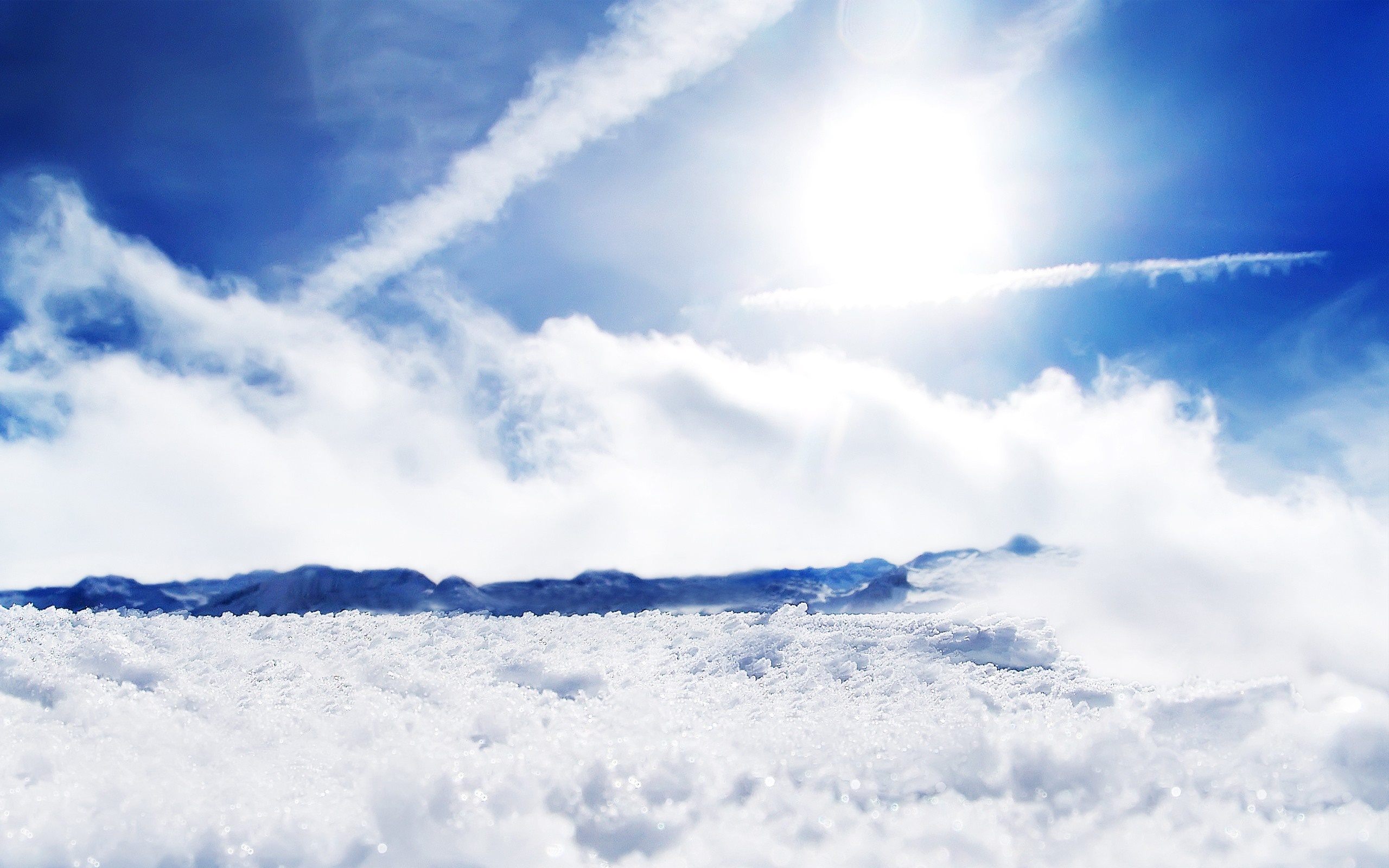 Snowy mountain landscape under a bright blue sky with clouds HD Wallpaper