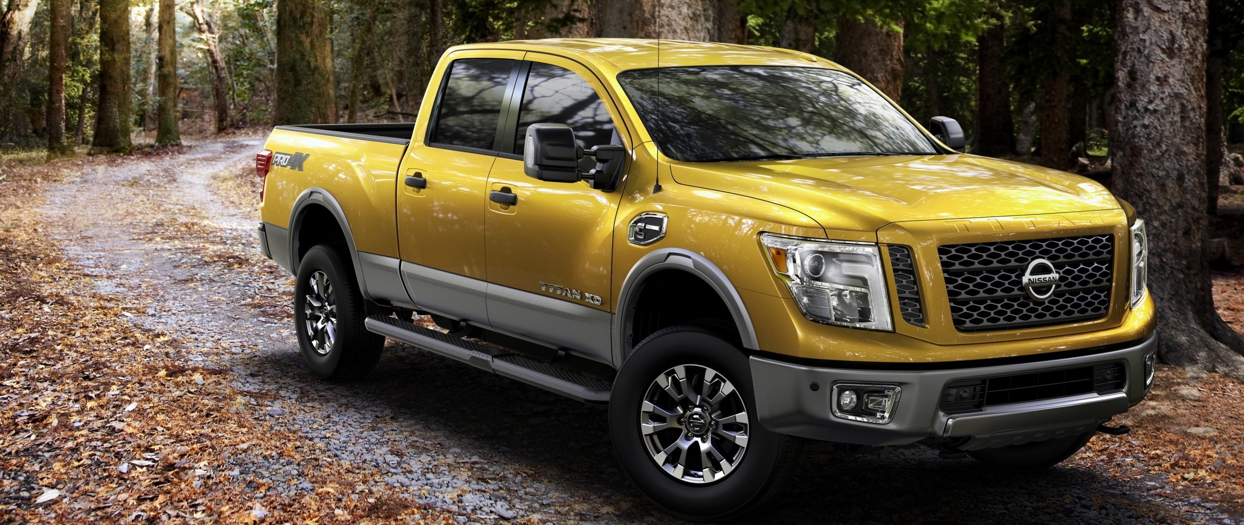 Yellow Nissan Titan XD pickup truck on a forest road HD Wallpaper