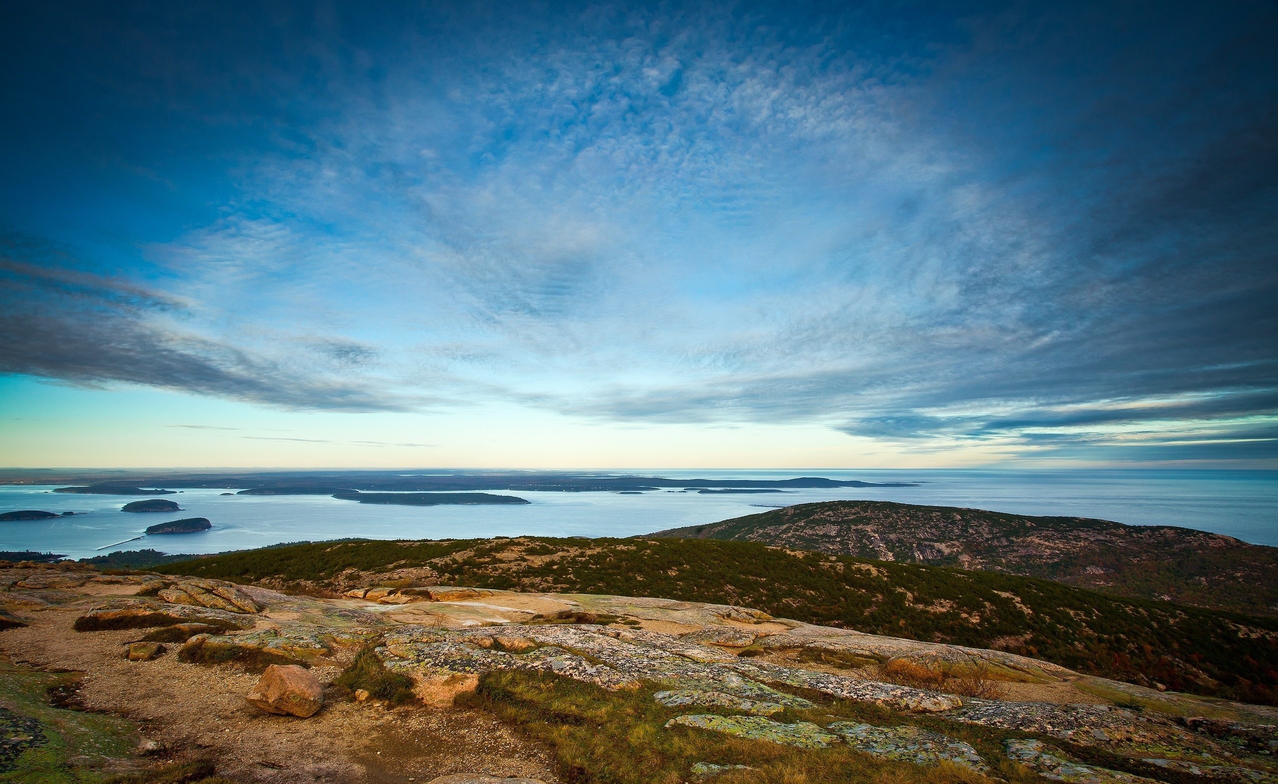 Rocky hill overlooking ocean and islands at sunrise HD Wallpaper