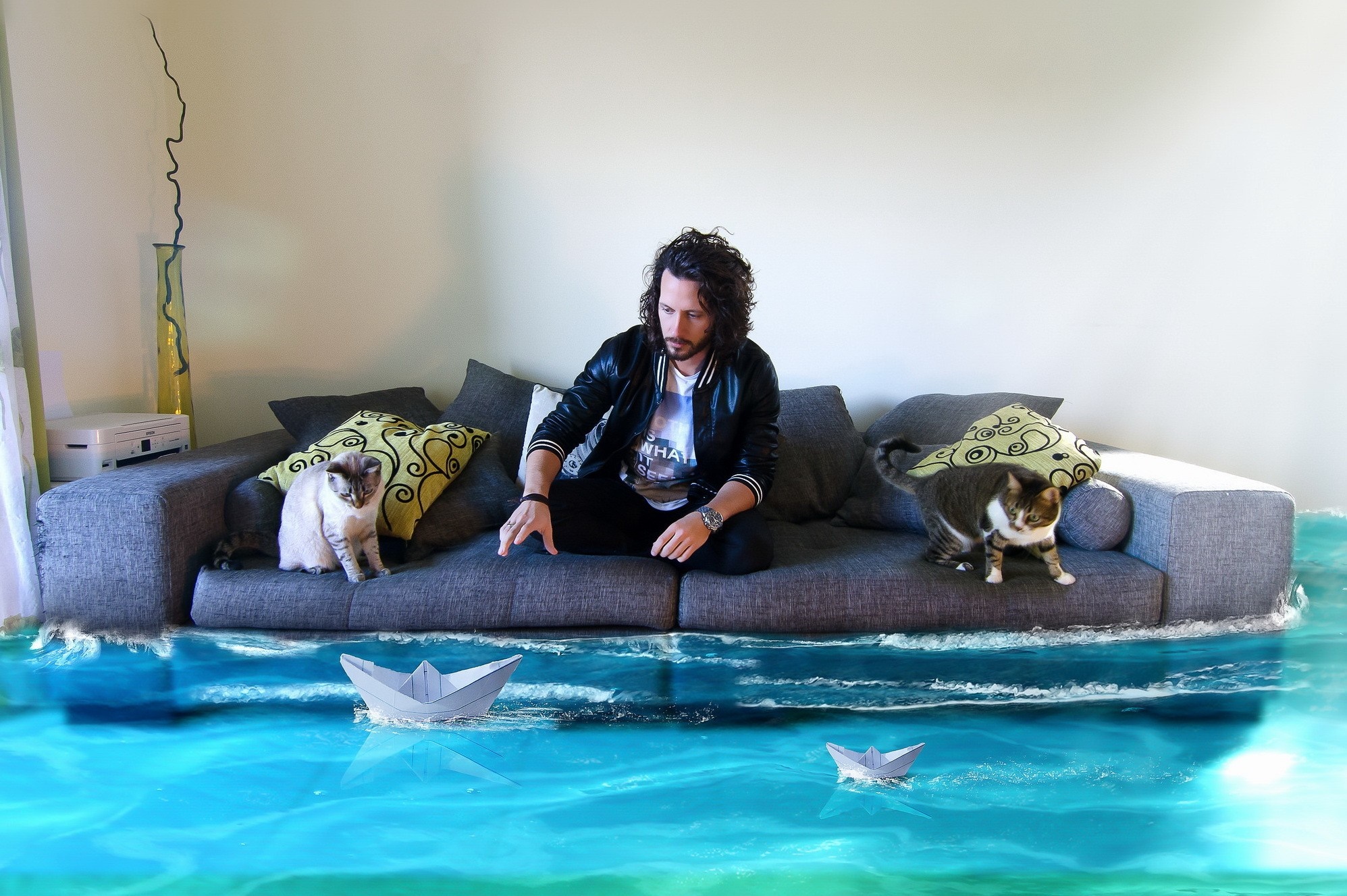 Man and cats on a flooded couch with paper boats HD Wallpaper