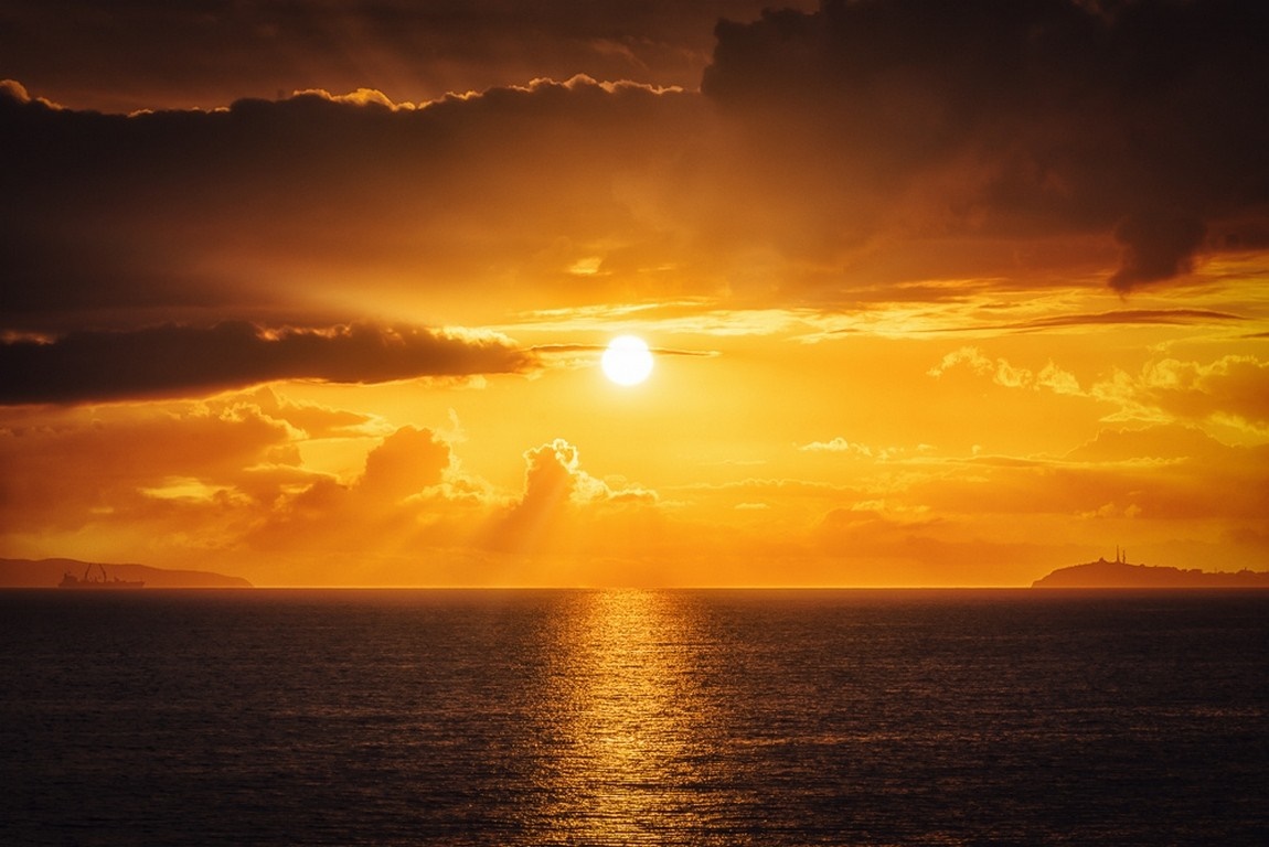 Sunset over the ocean with dramatic clouds HD Wallpaper