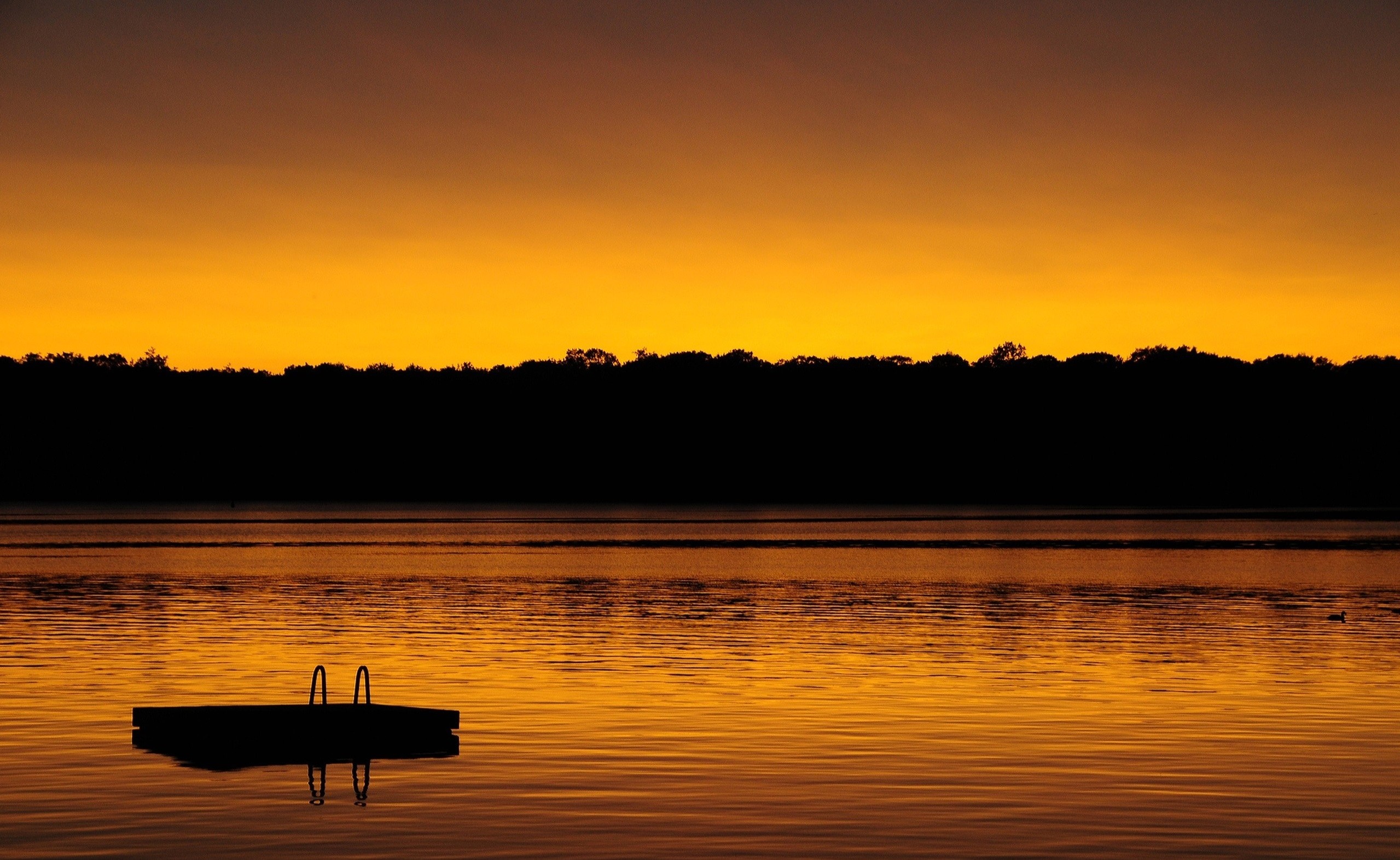Sunset over a calm lake with a dock HD Wallpaper