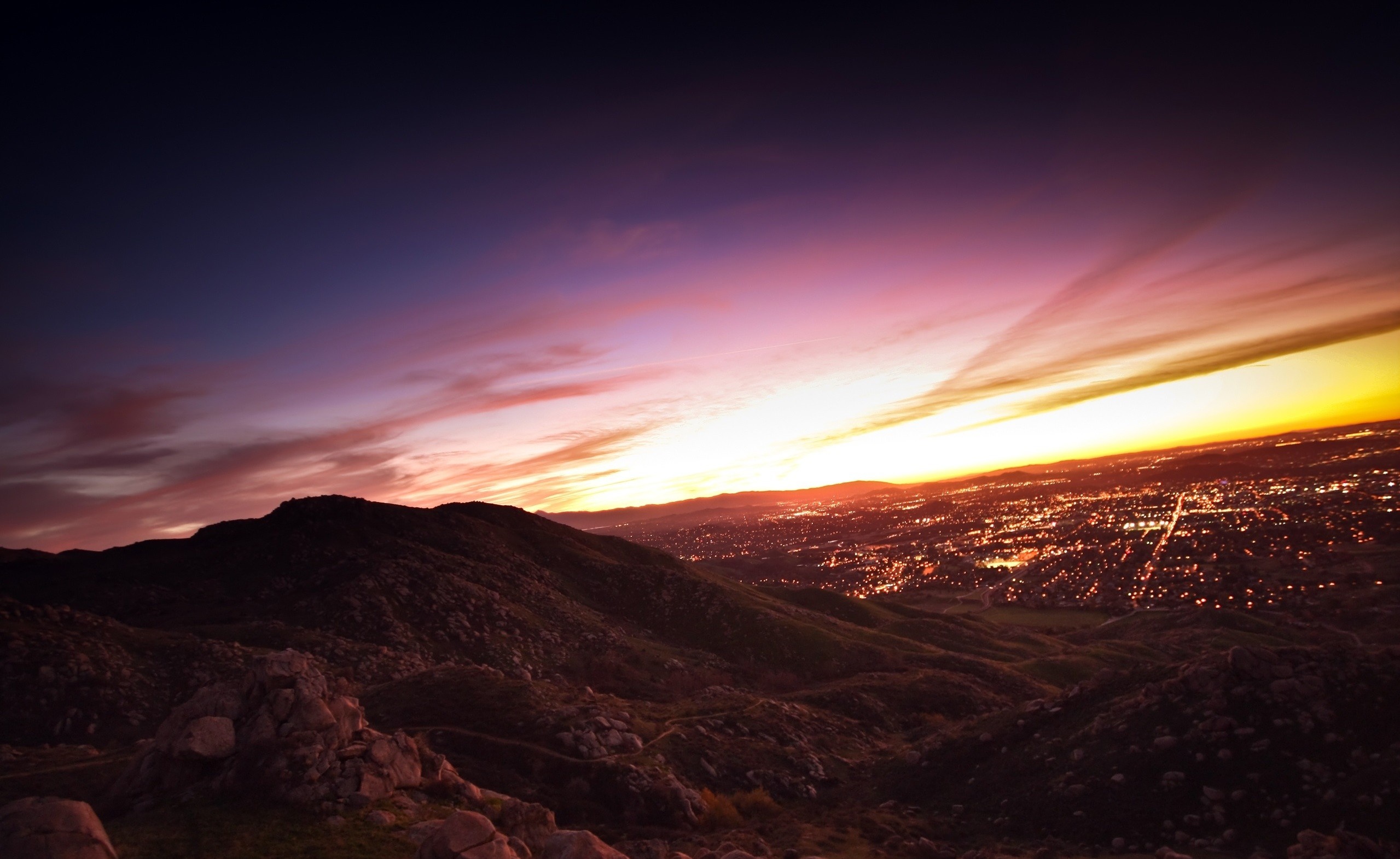 City lights at sunset over mountains HD Wallpaper