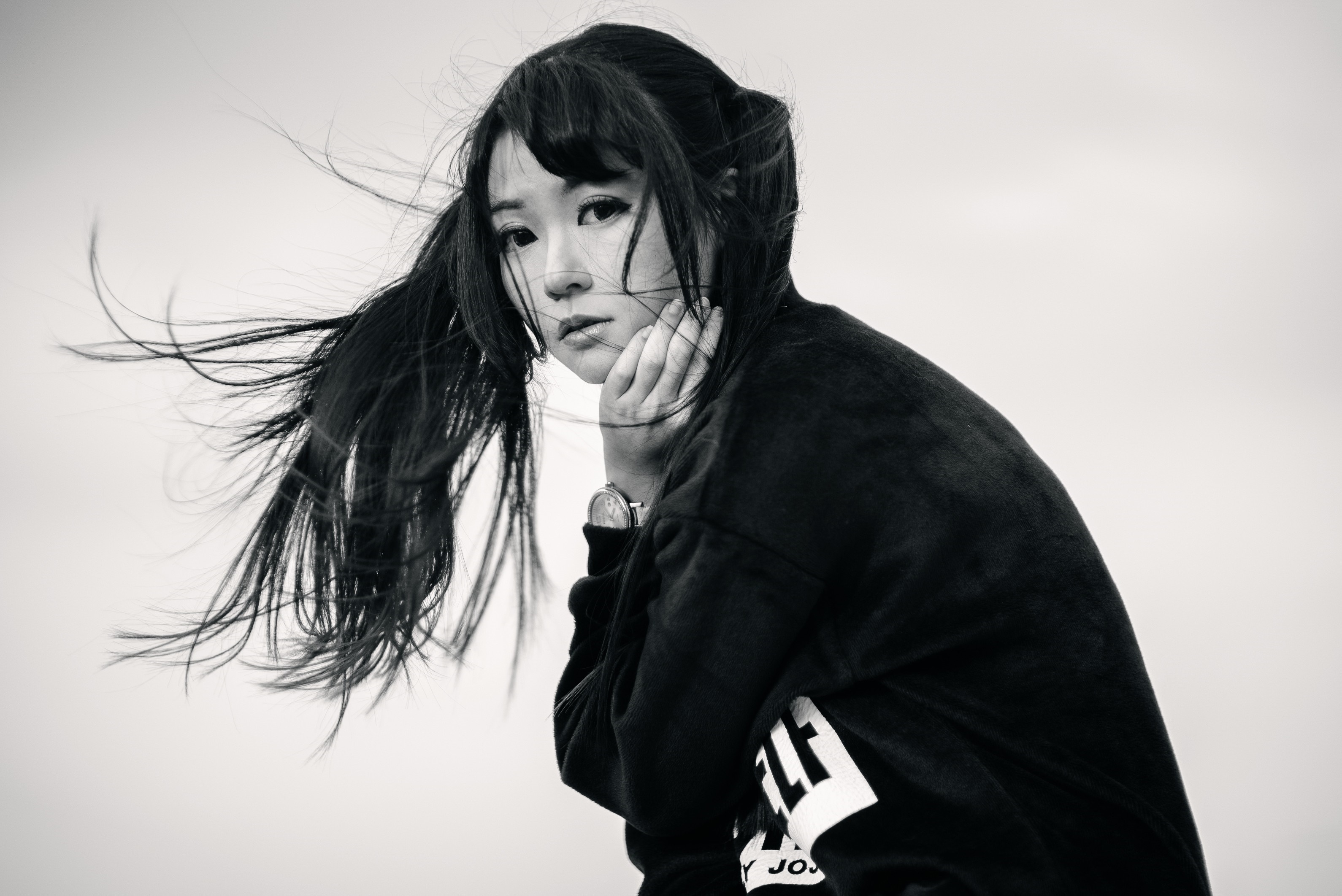 Monochrome portrait of an Asian woman with windblown hair HD Wallpaper