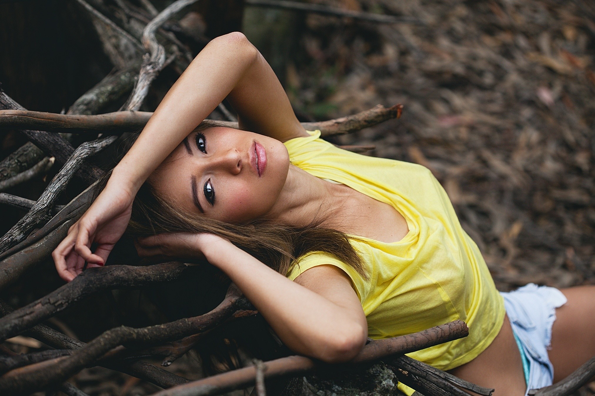 Woman in yellow shirt lying on branches HD Wallpaper