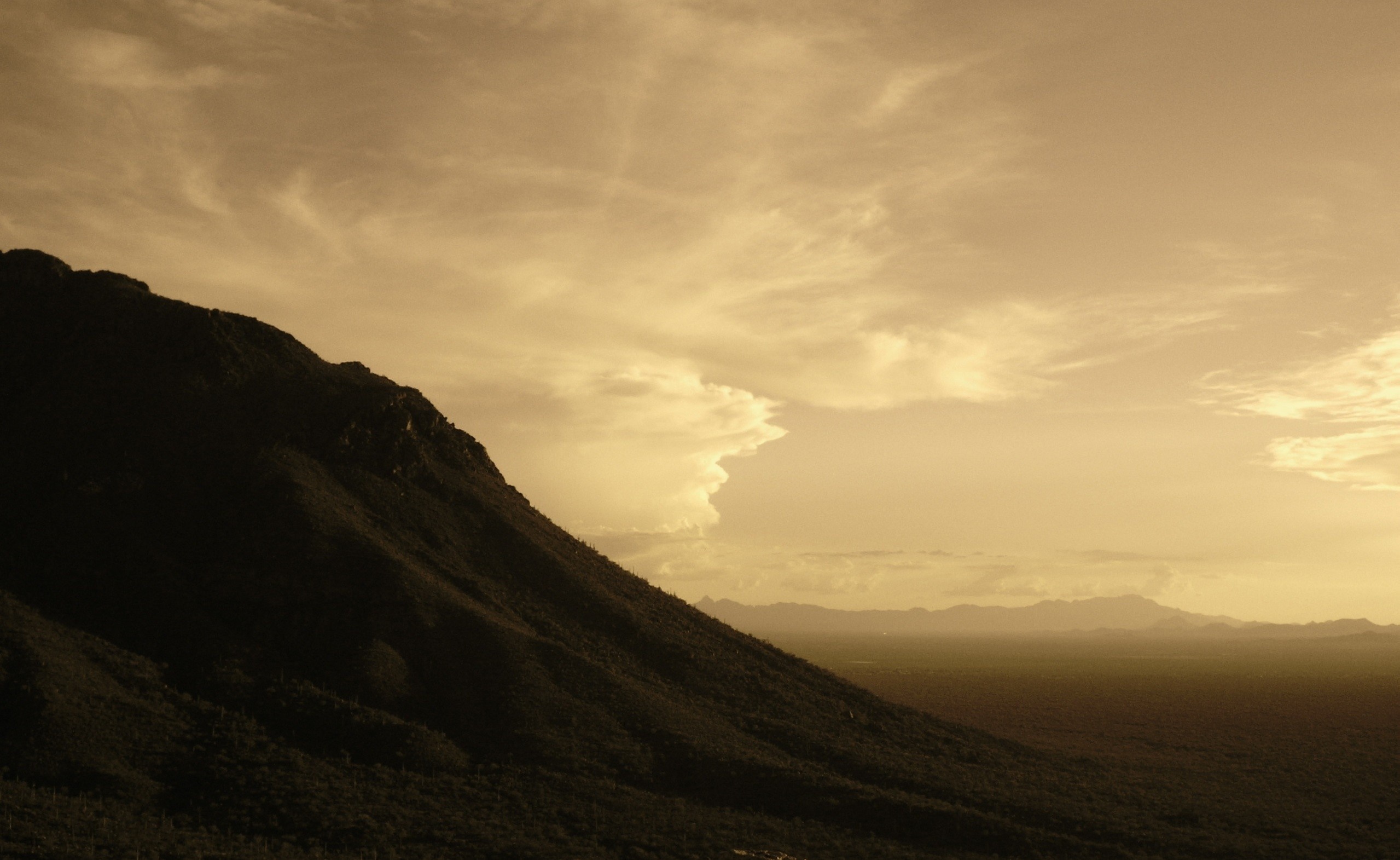 Mountain slope against a cloudy sky at sunset HD Wallpaper