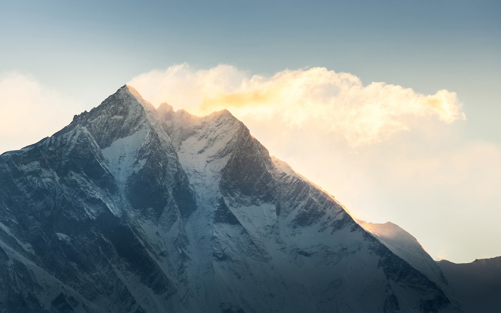 Snow-capped mountain peak with sunlight and clouds HD Wallpaper