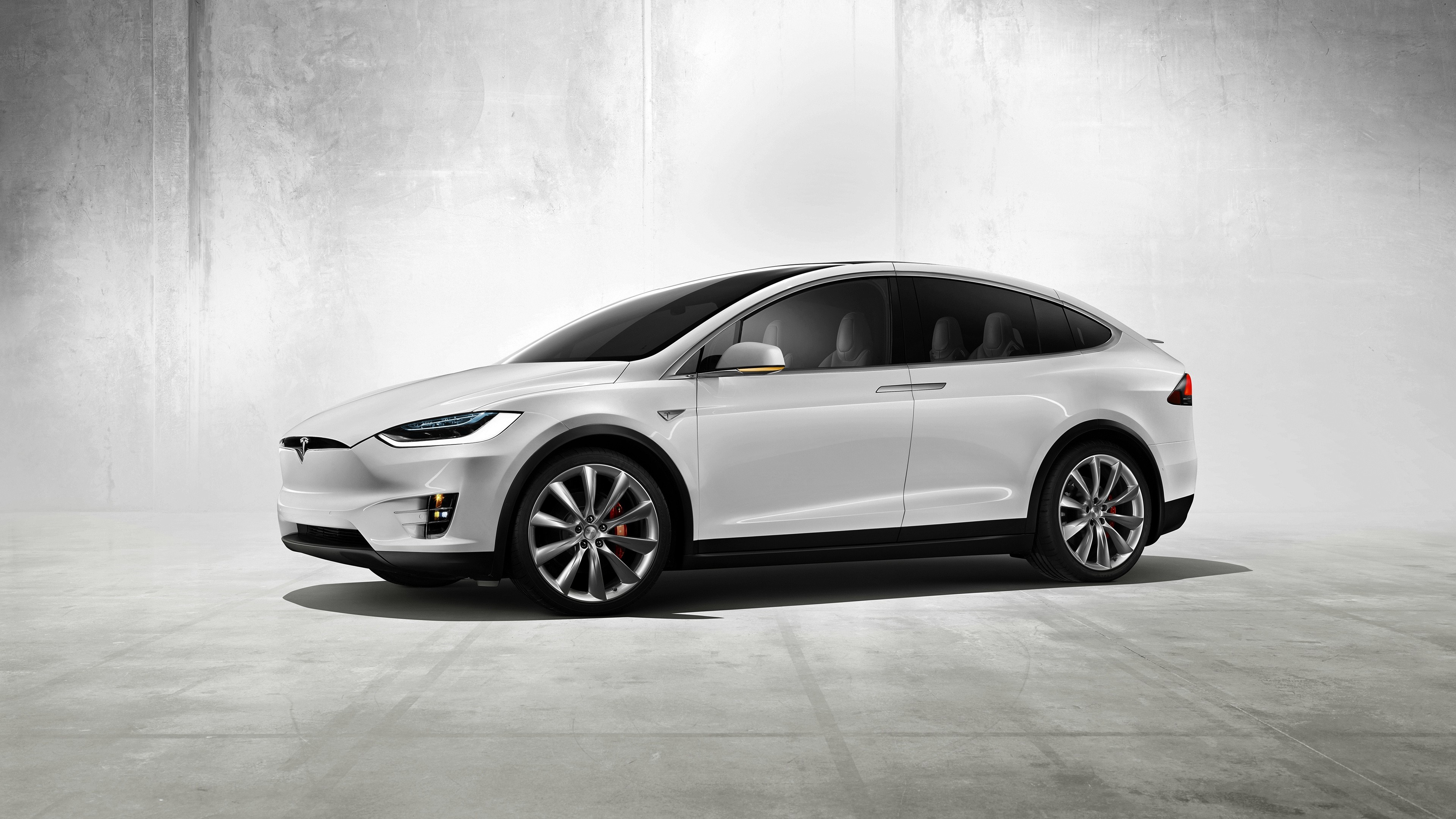 White Tesla Model X parked on concrete floor HD Wallpaper