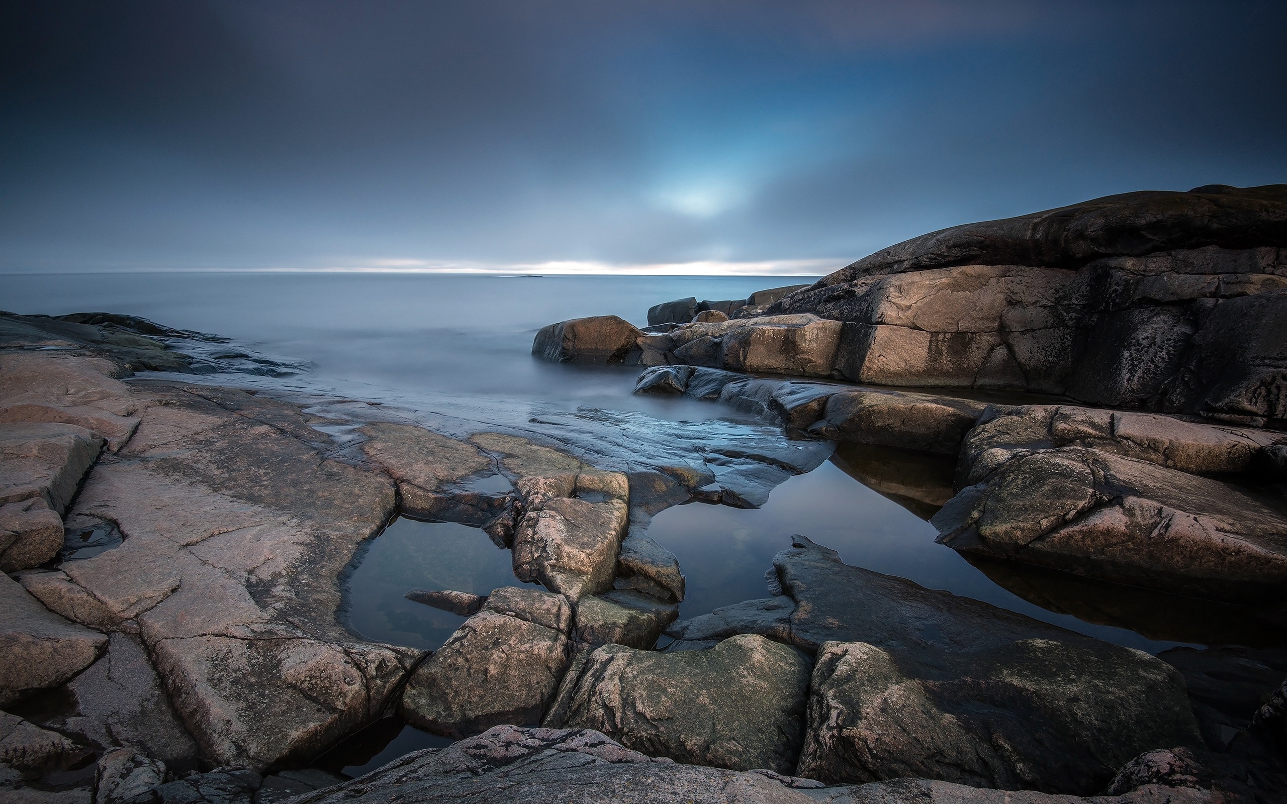 Rocky coast with calm ocean at dusk HD Wallpaper