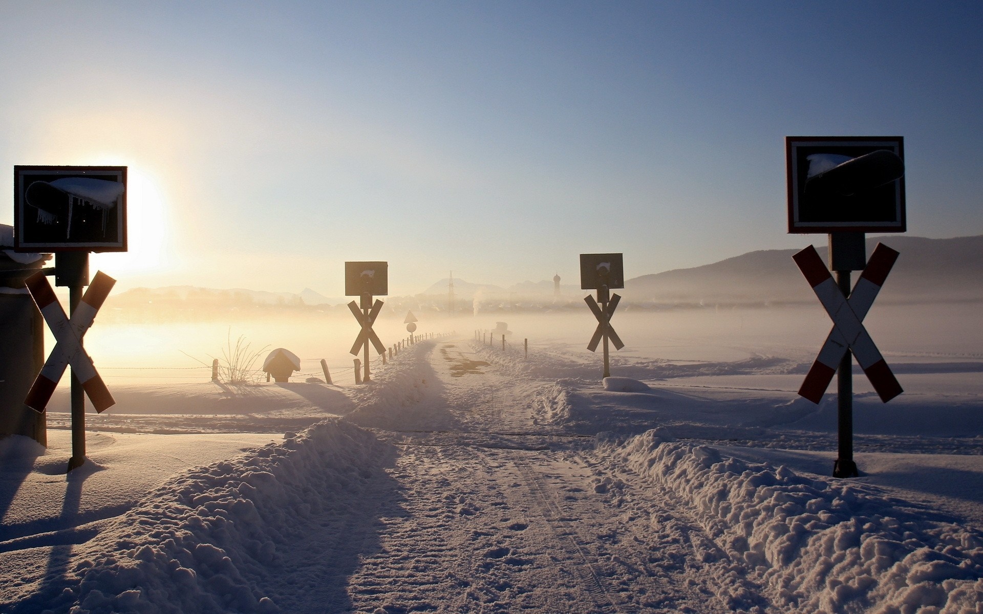 Snowy landscape with railroad crossing signs at sunrise HD Wallpaper