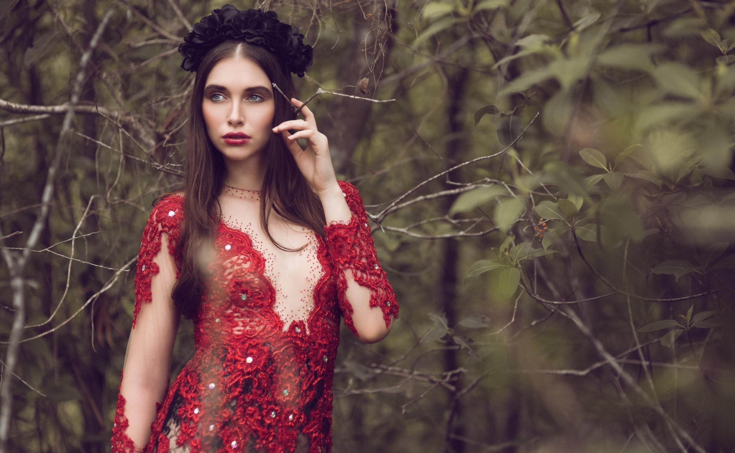 Woman in red dress with black flower crown in forest HD Wallpaper