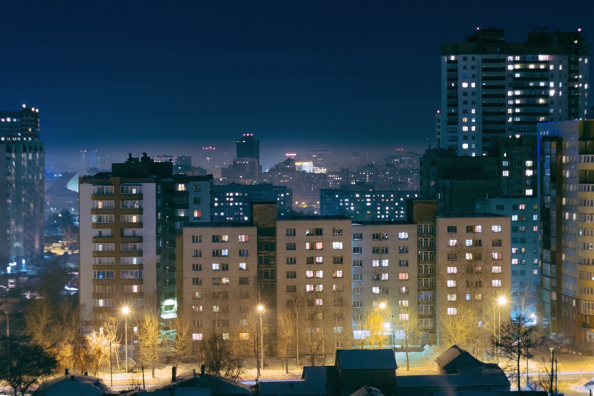 Cityscape at night with illuminated apartment buildings HD Wallpaper