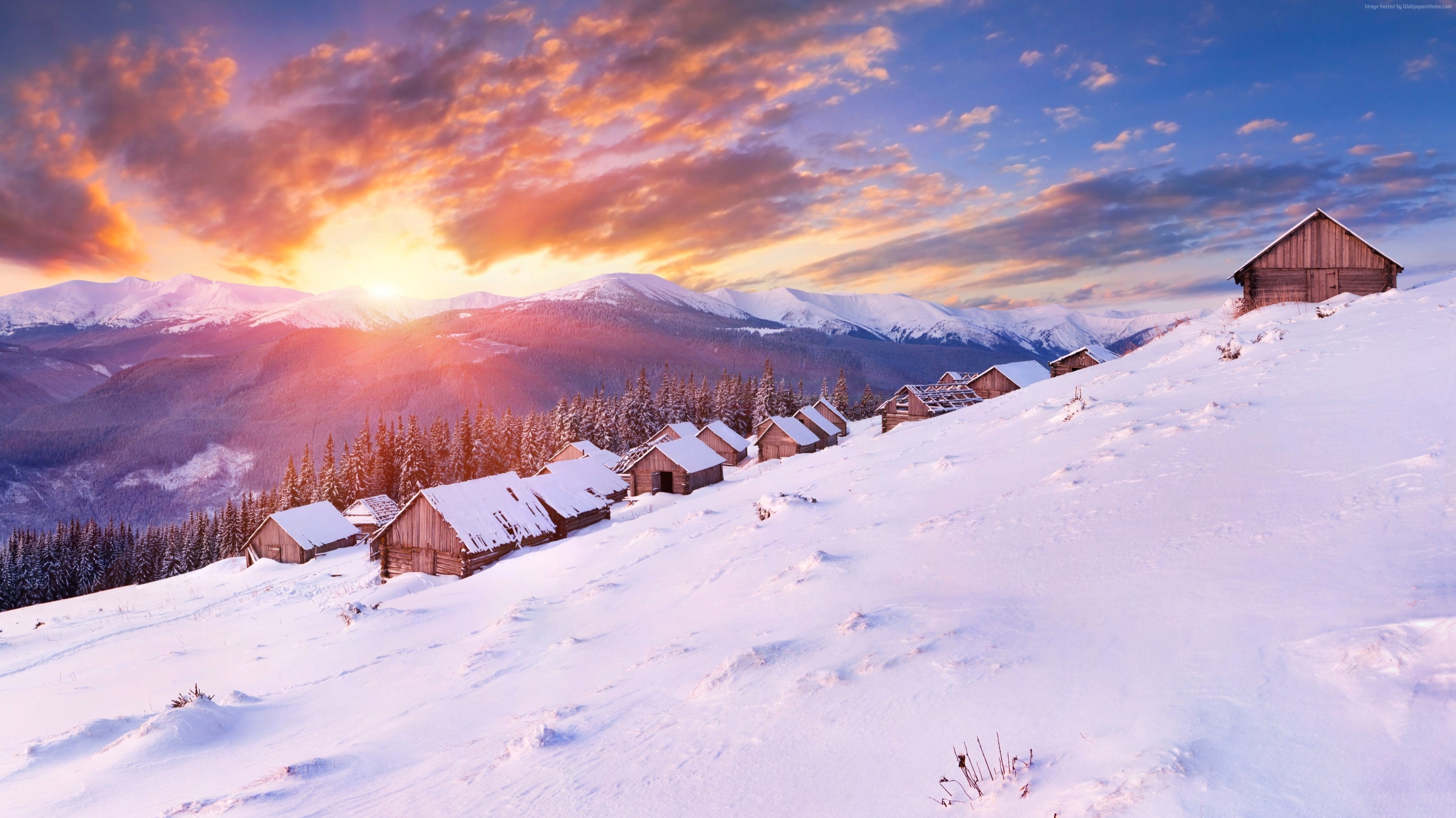 Wooden houses on a snowy mountain slope at sunset HD Wallpaper