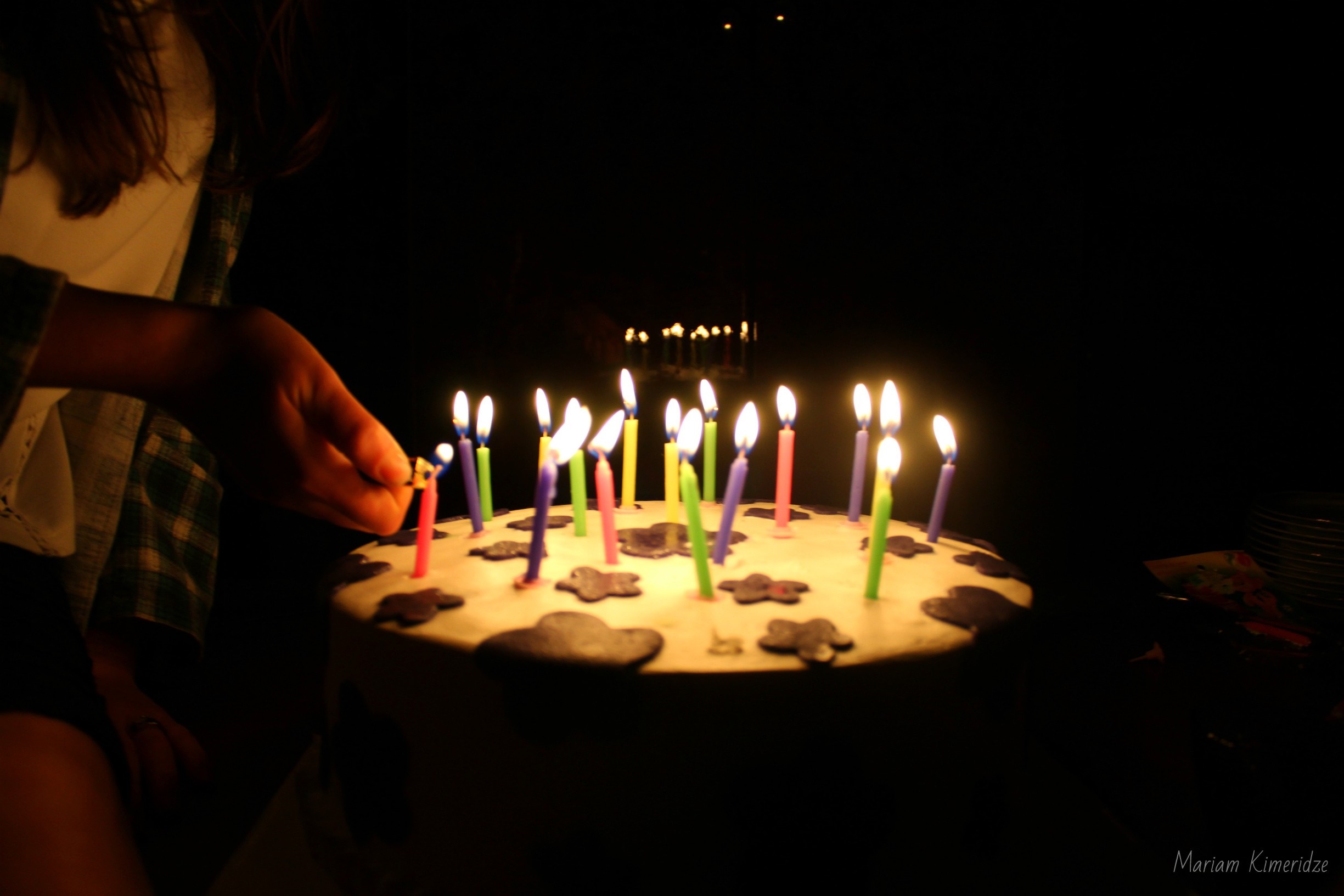 Person lighting birthday cake candles at night HD Wallpaper