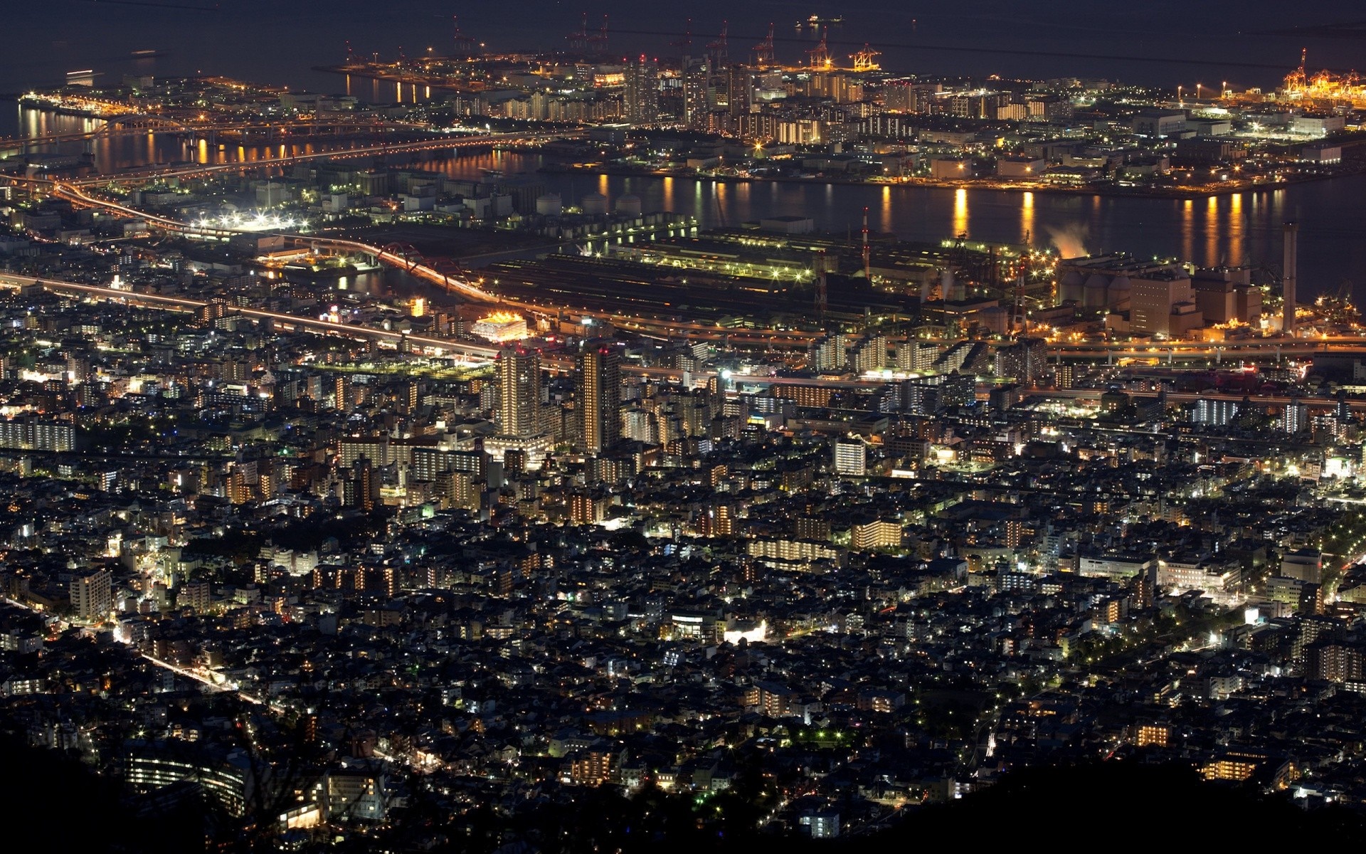 Cityscape at night with illuminated buildings and harbor HD Wallpaper