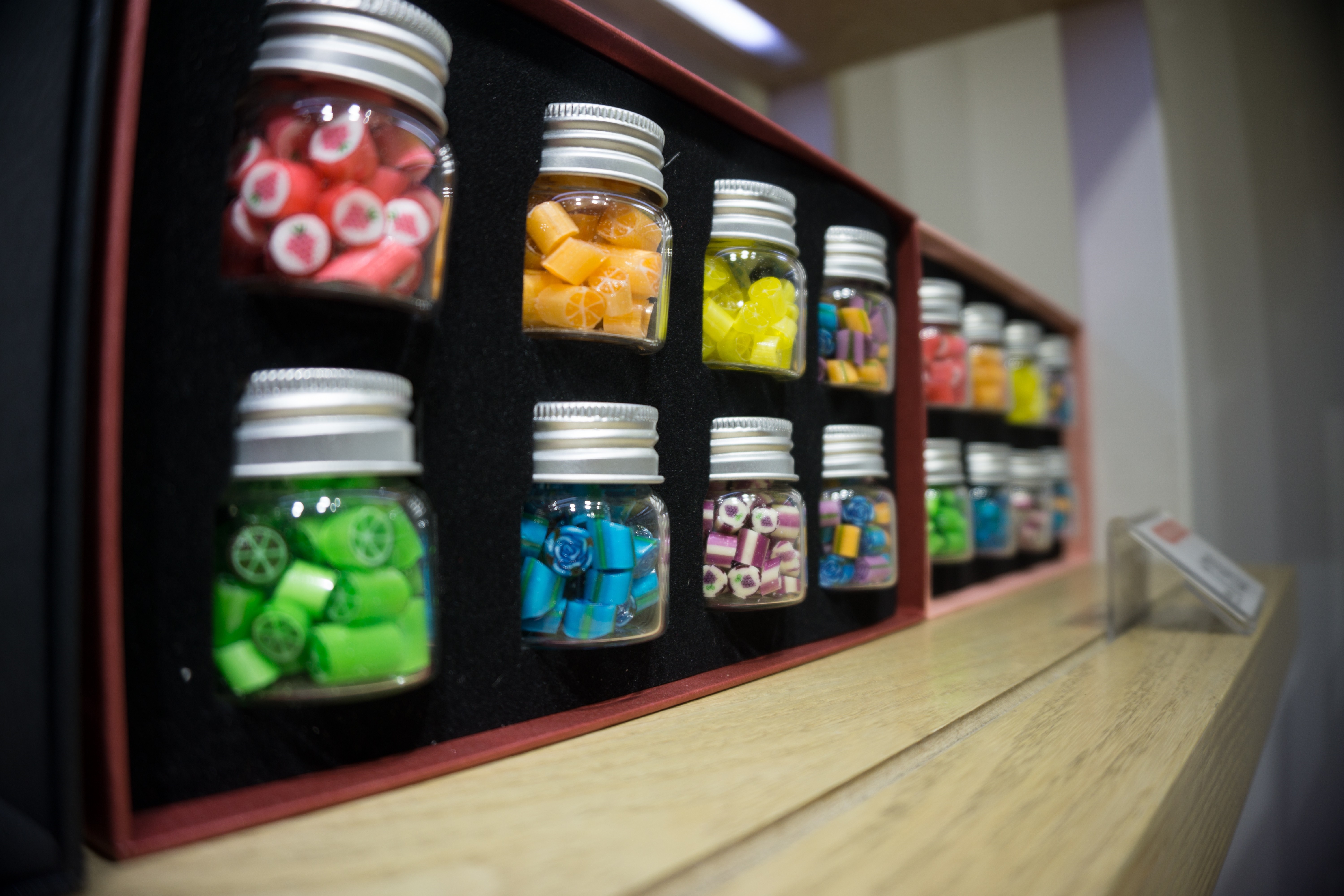 Jars of colorful hard candies on display HD Wallpaper
