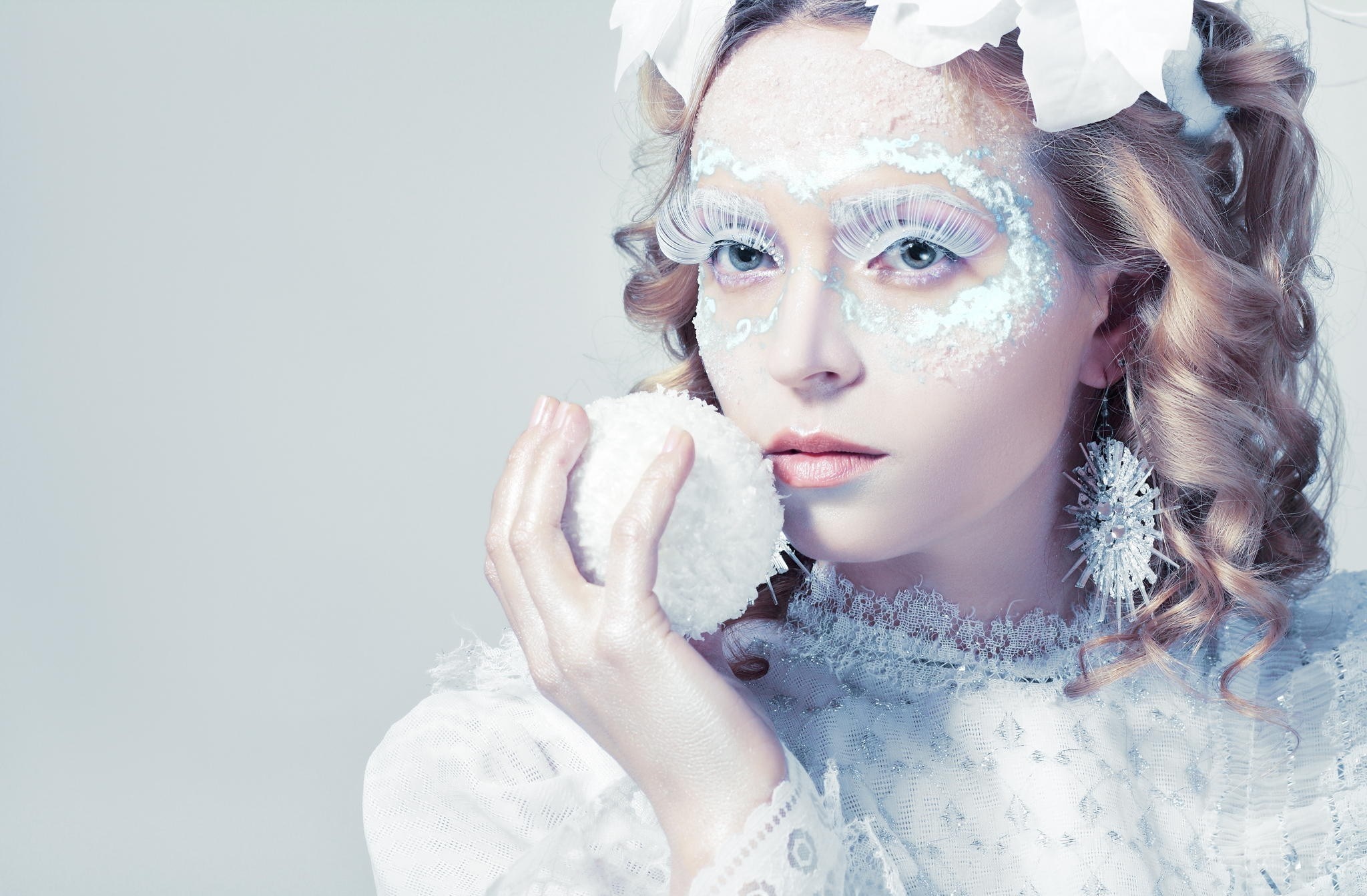 Woman with winter-themed makeup holding a snowball HD Wallpaper