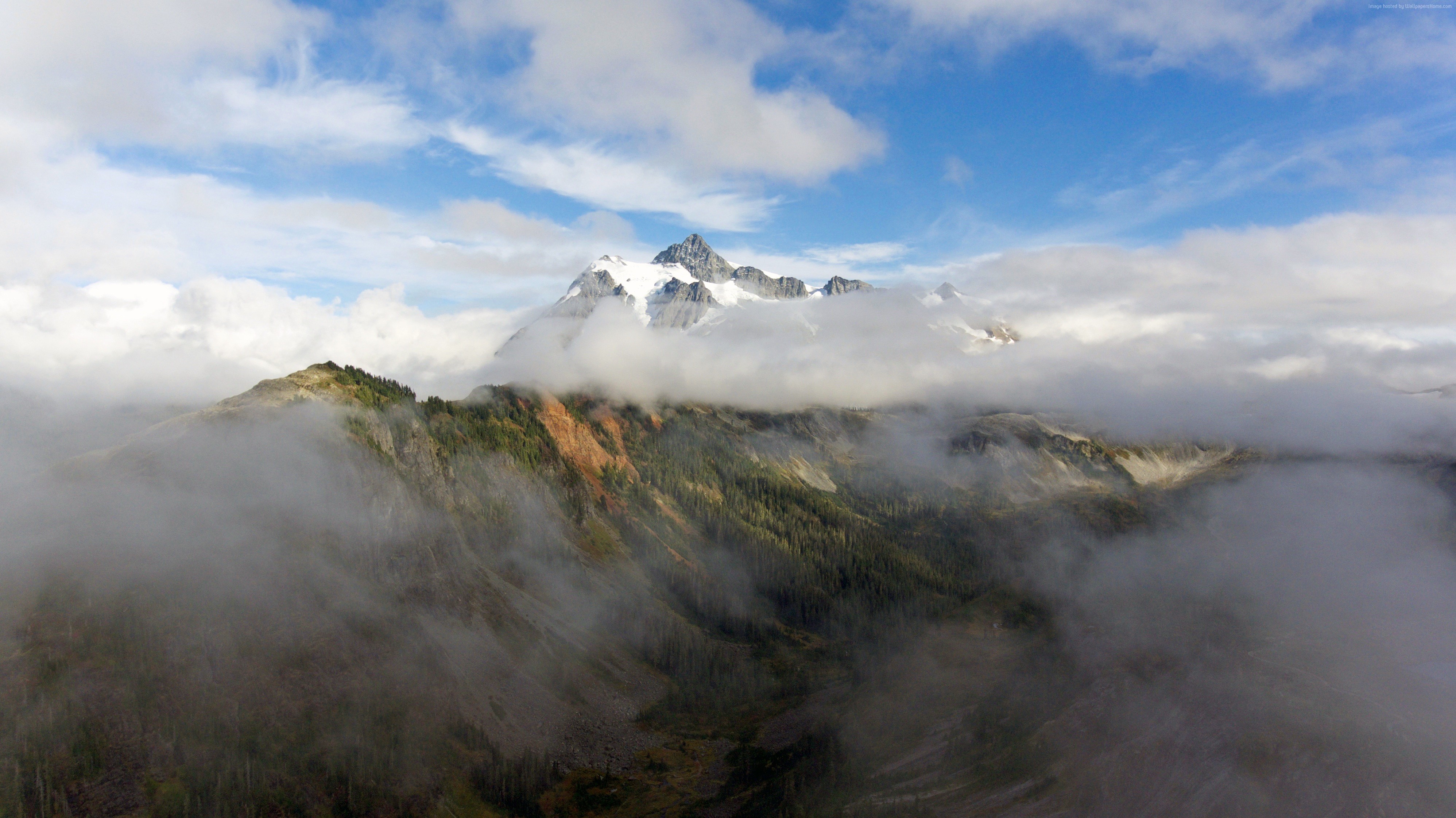 Snow-capped mountains shrouded in clouds and fog HD Wallpaper