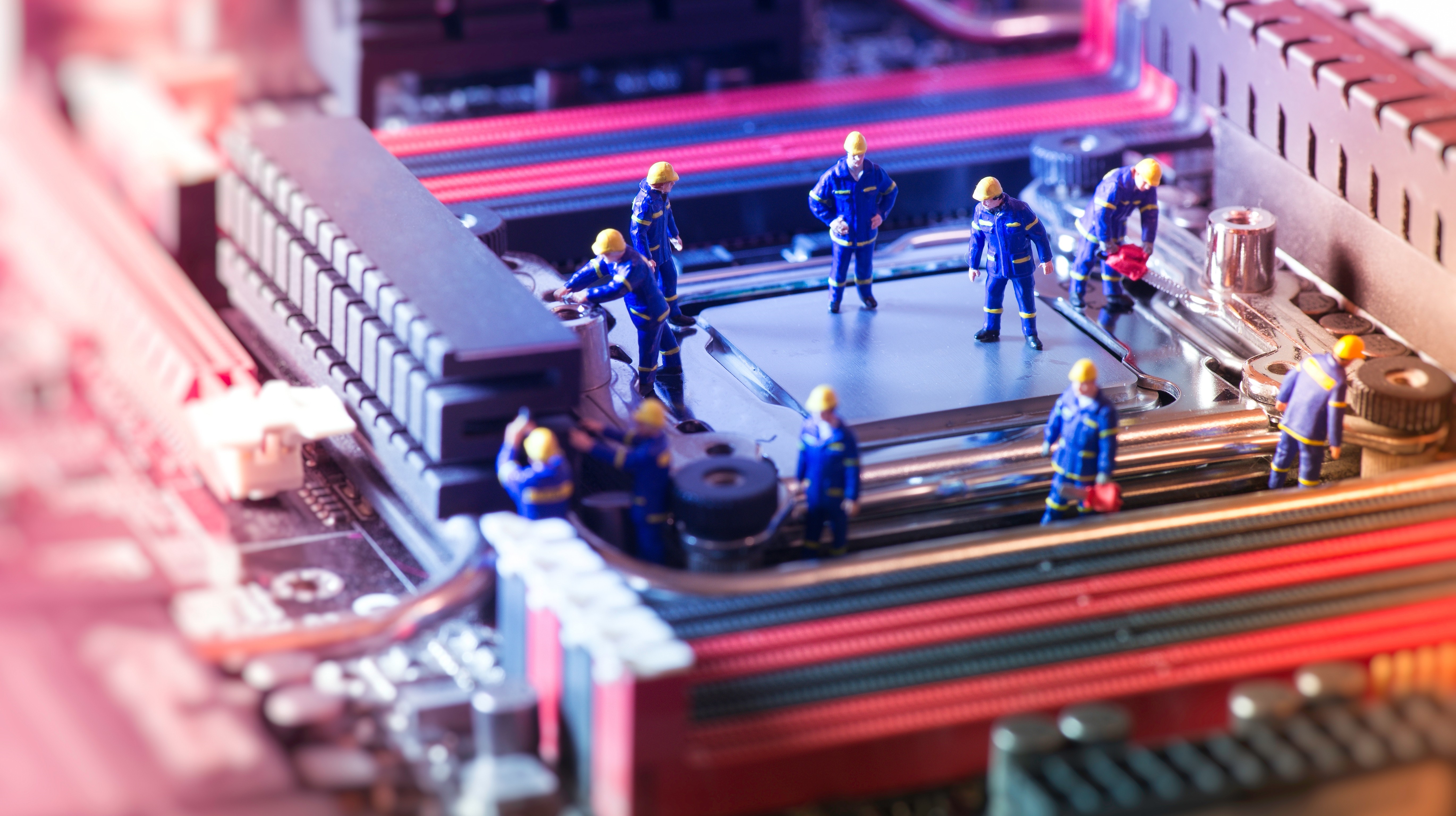 Miniature workers on a computer motherboard HD Wallpaper