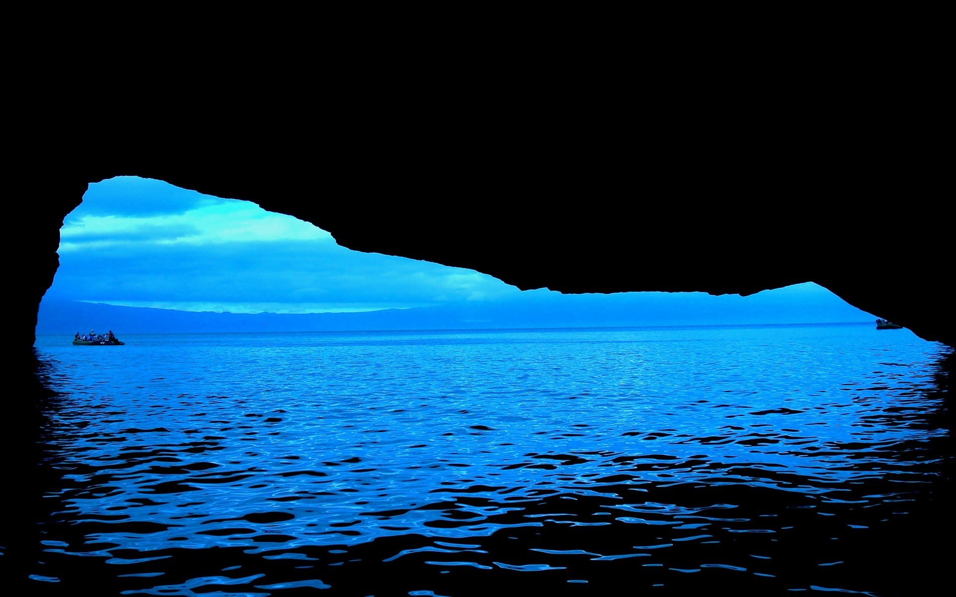 View from a cave of a boat on the blue ocean HD Wallpaper