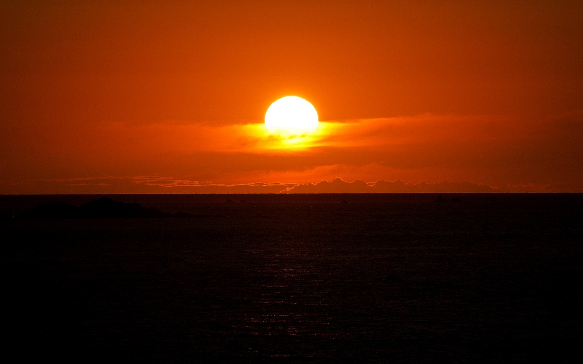 Sunset over the ocean with a bright sun on the horizon HD Wallpaper