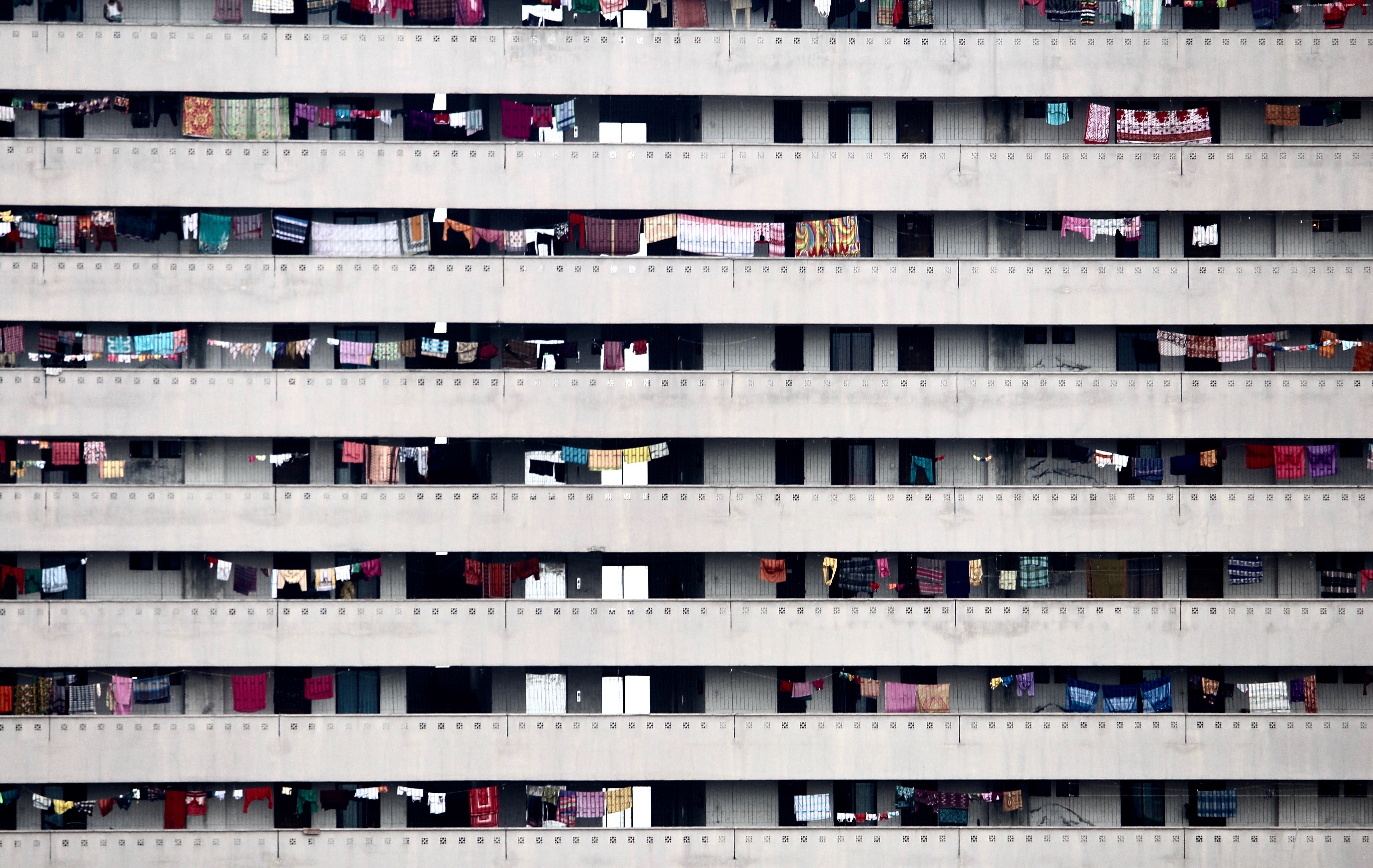 Apartment building with laundry hanging from balconies HD Wallpaper