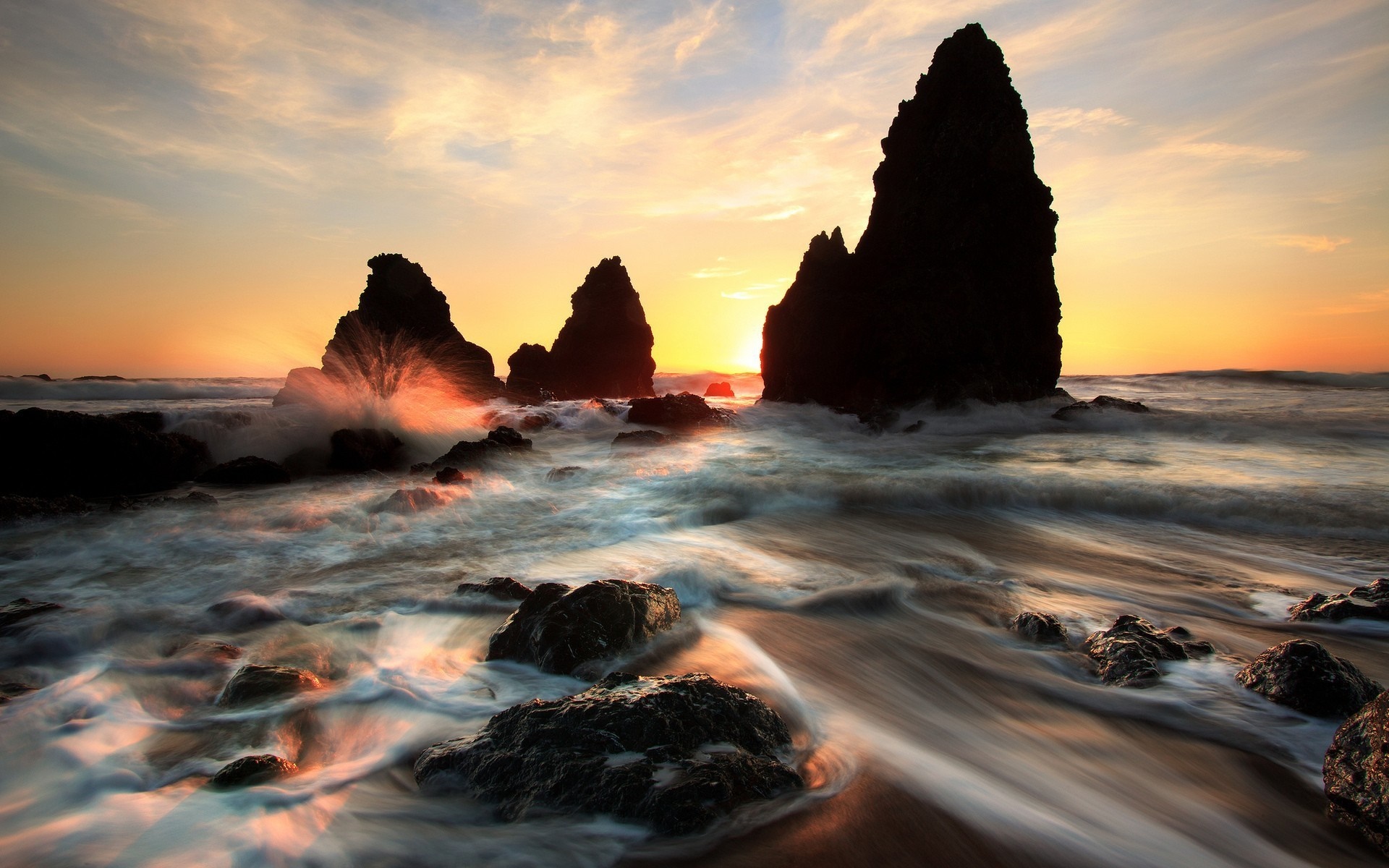 Sunset over rocky coast with waves crashing HD Wallpaper