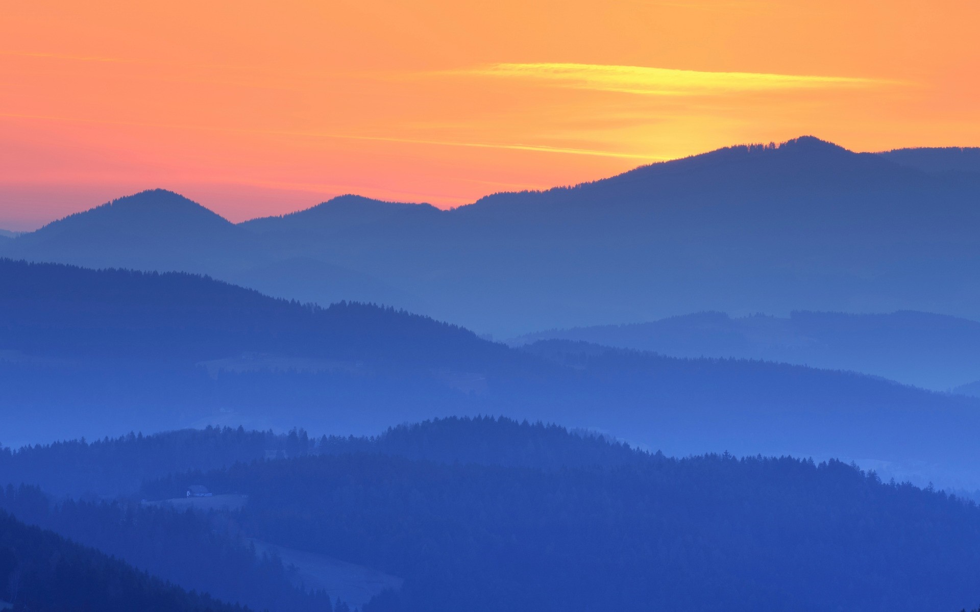 Layered mountains at sunset with orange sky HD Wallpaper