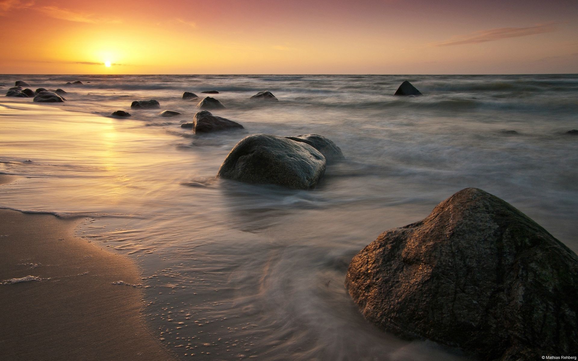 Sunset over the sea with rocks on the shore HD Wallpaper