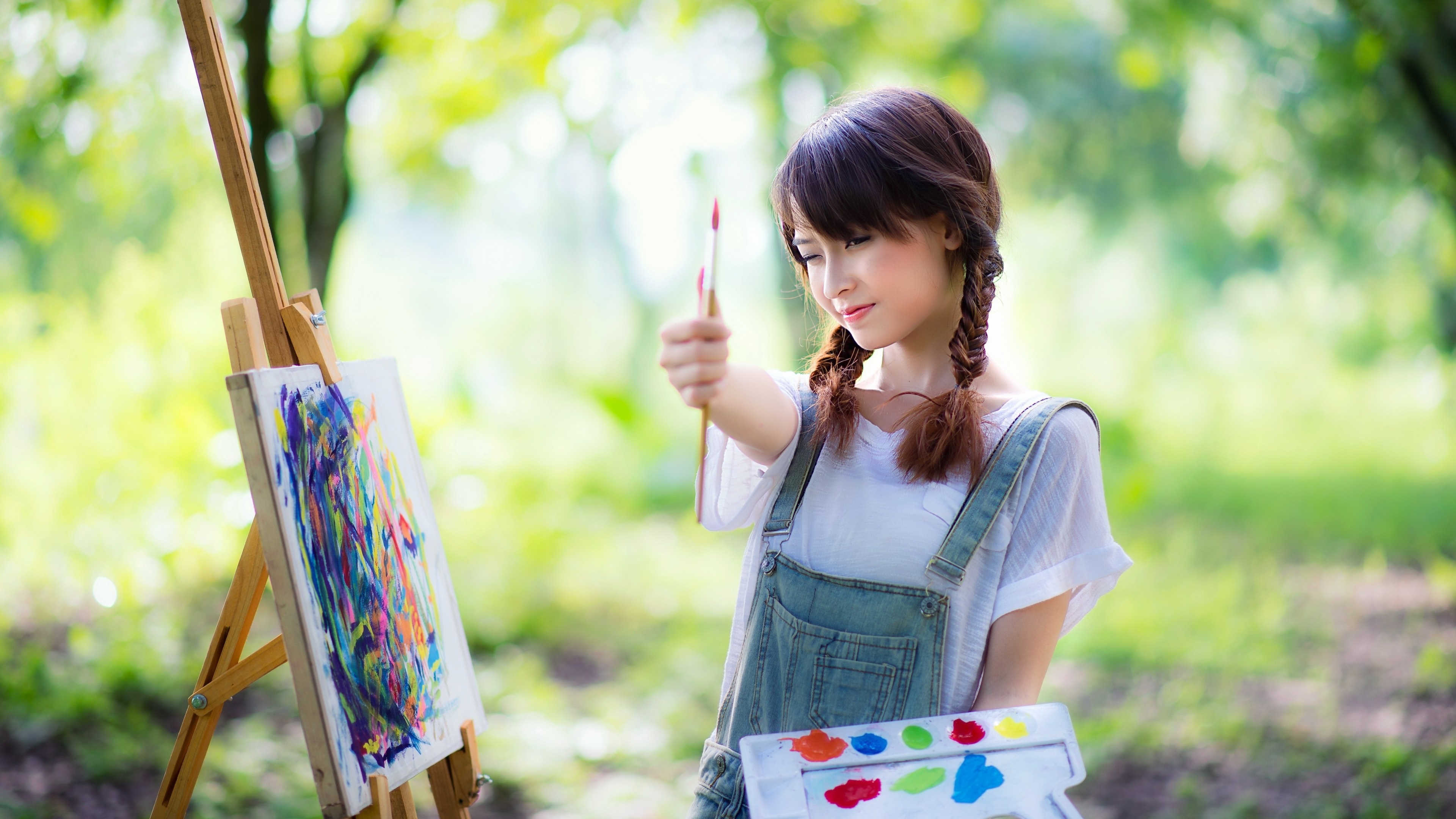 Young woman painting outdoors with easel and palette HD Wallpaper