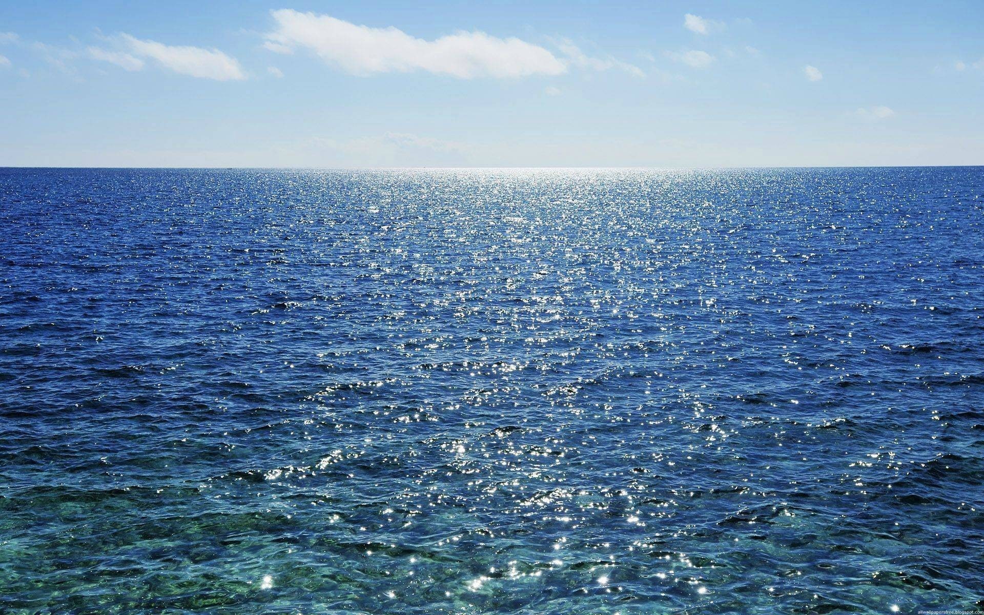 Ocean horizon with sparkling water and clouds HD Wallpaper