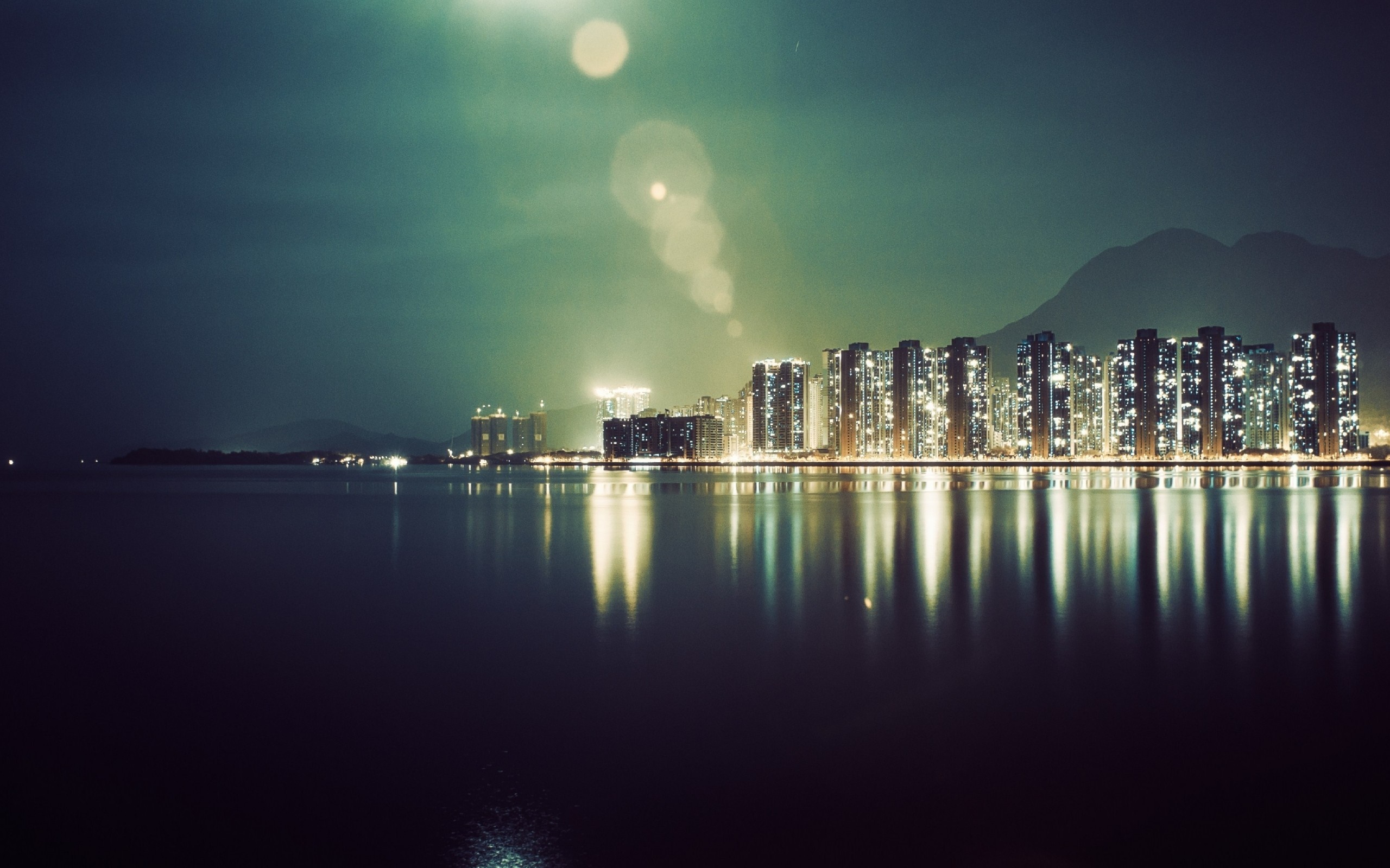 Cityscape at night with reflections on the water HD Wallpaper